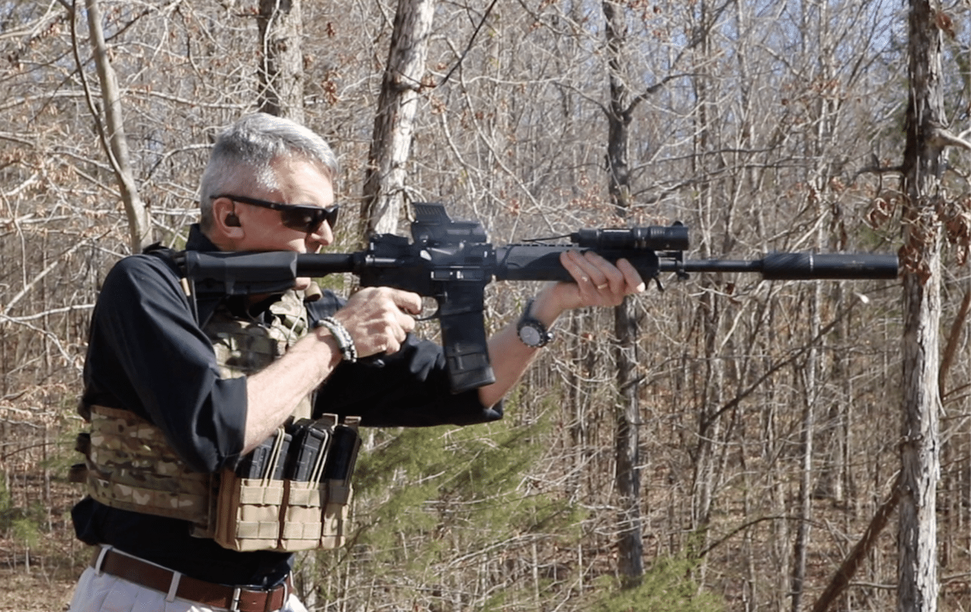 Man shooting a SAINT rifle with MOLLE plate carrier
