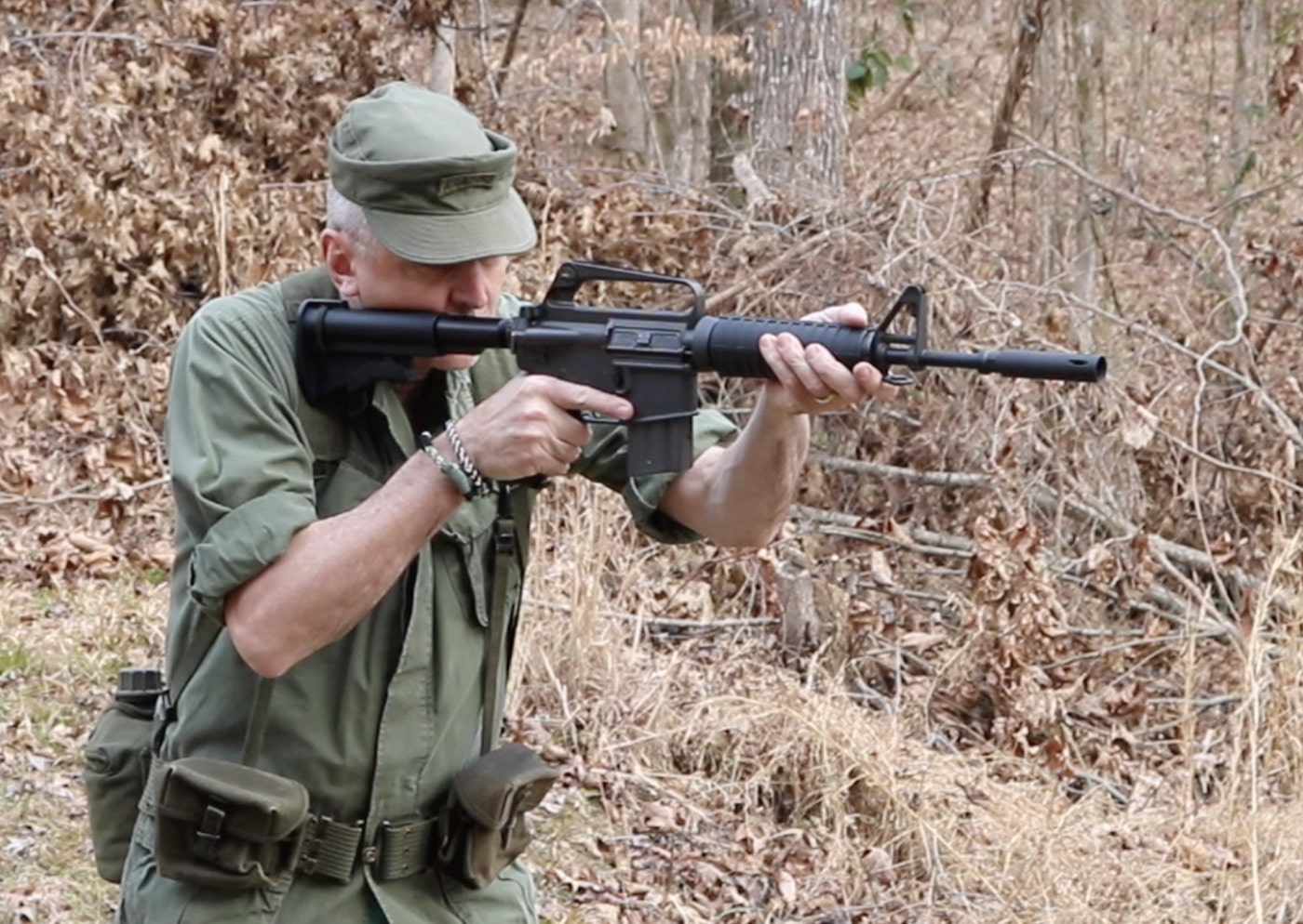 Man demonstrating older load bearing equipment in the US military