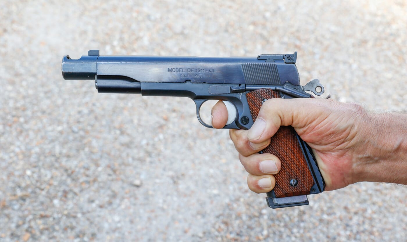 Demonstration of curled down thumb for pistol shooting