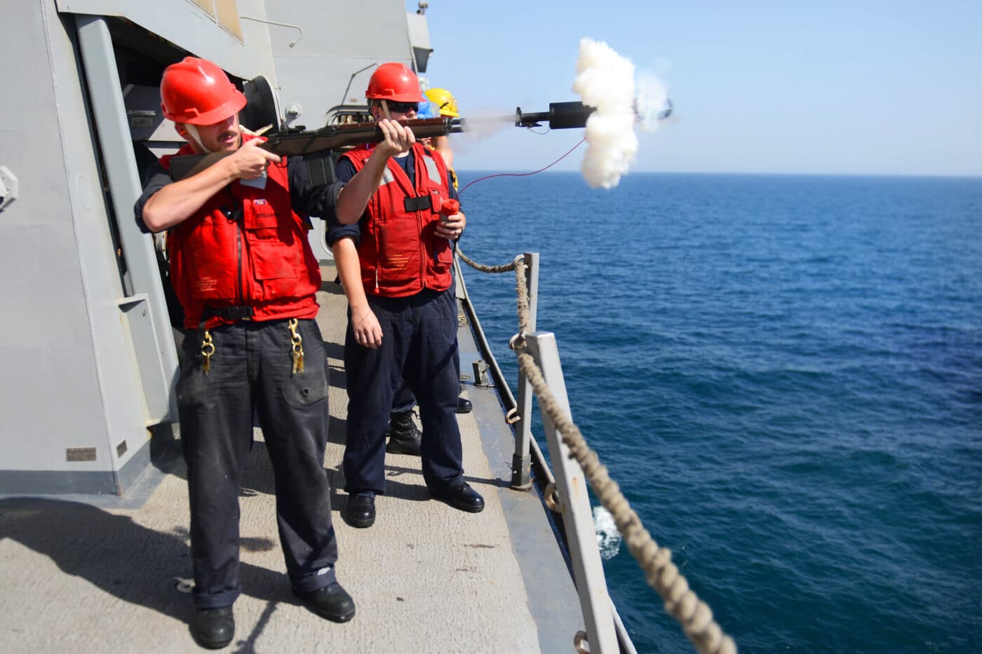 Sailors use an M14 to to fire a shot line