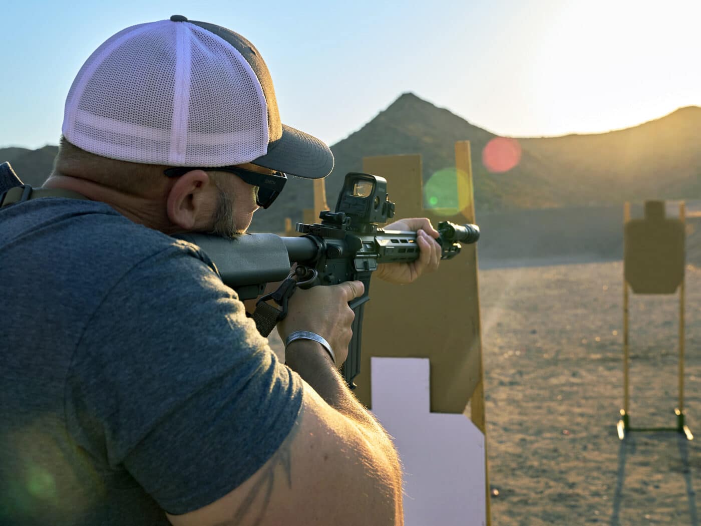 Man training with rifle in unusual shooting positions