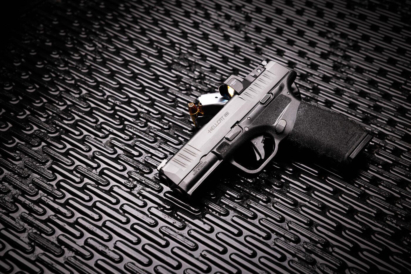 Springfield Hellcat Pro pistol resting on loaded magazine
