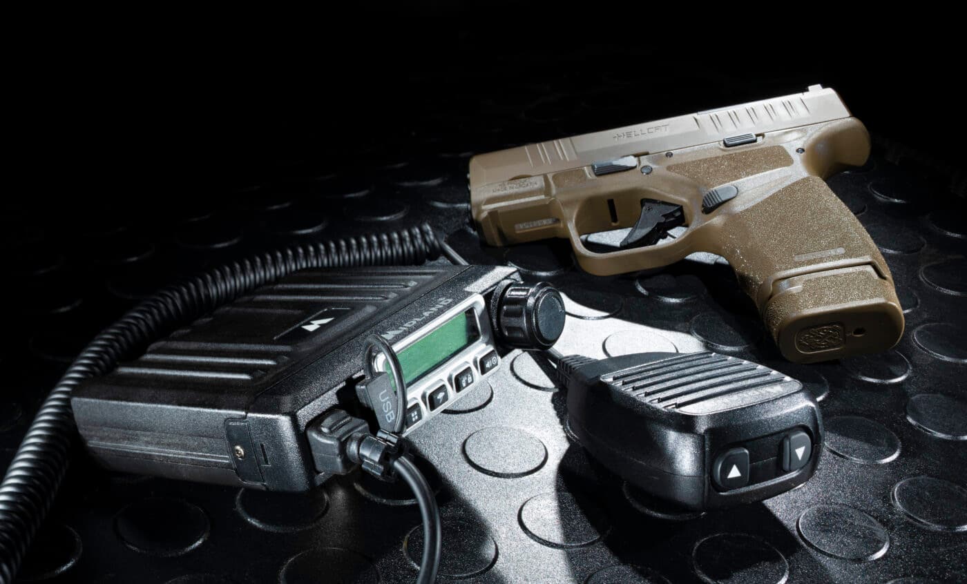 Springfield Hellcat pistol and radio on black mat