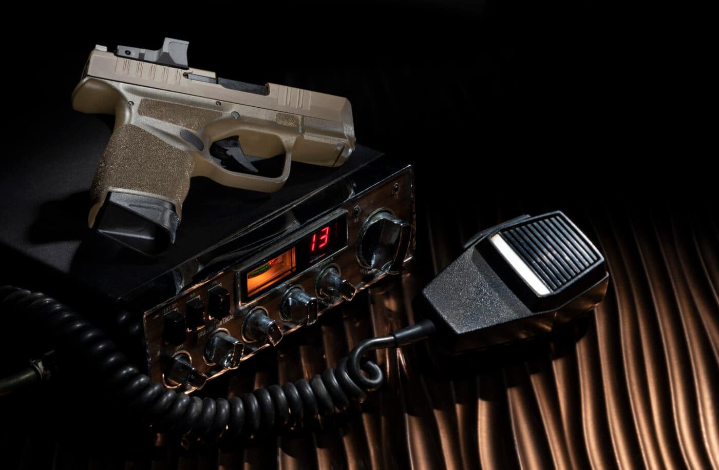 Springfield Hellcat pistol on top of an emergency radio