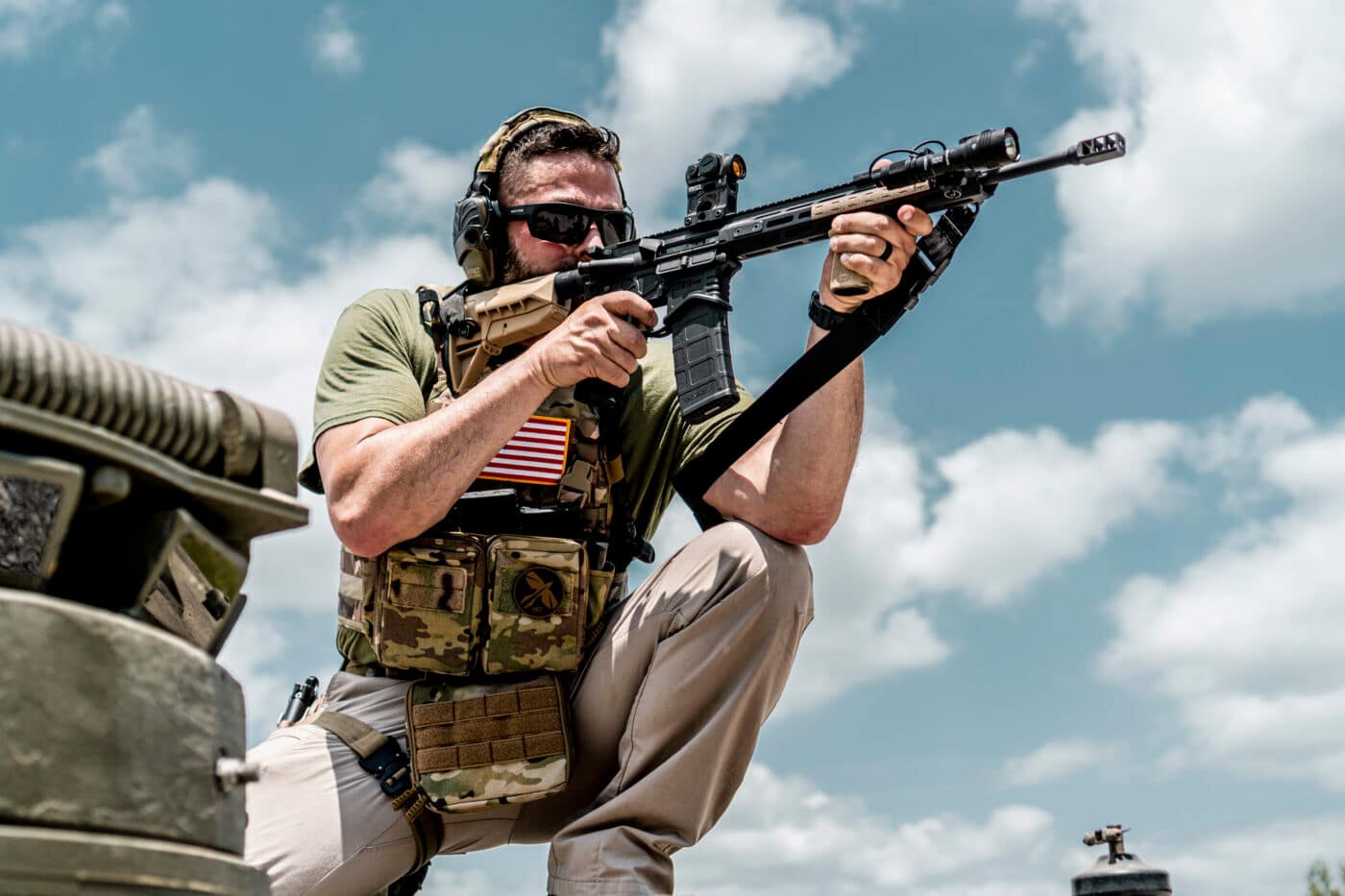 Man shooting rifle while wearing a minimalist plate carrier setup