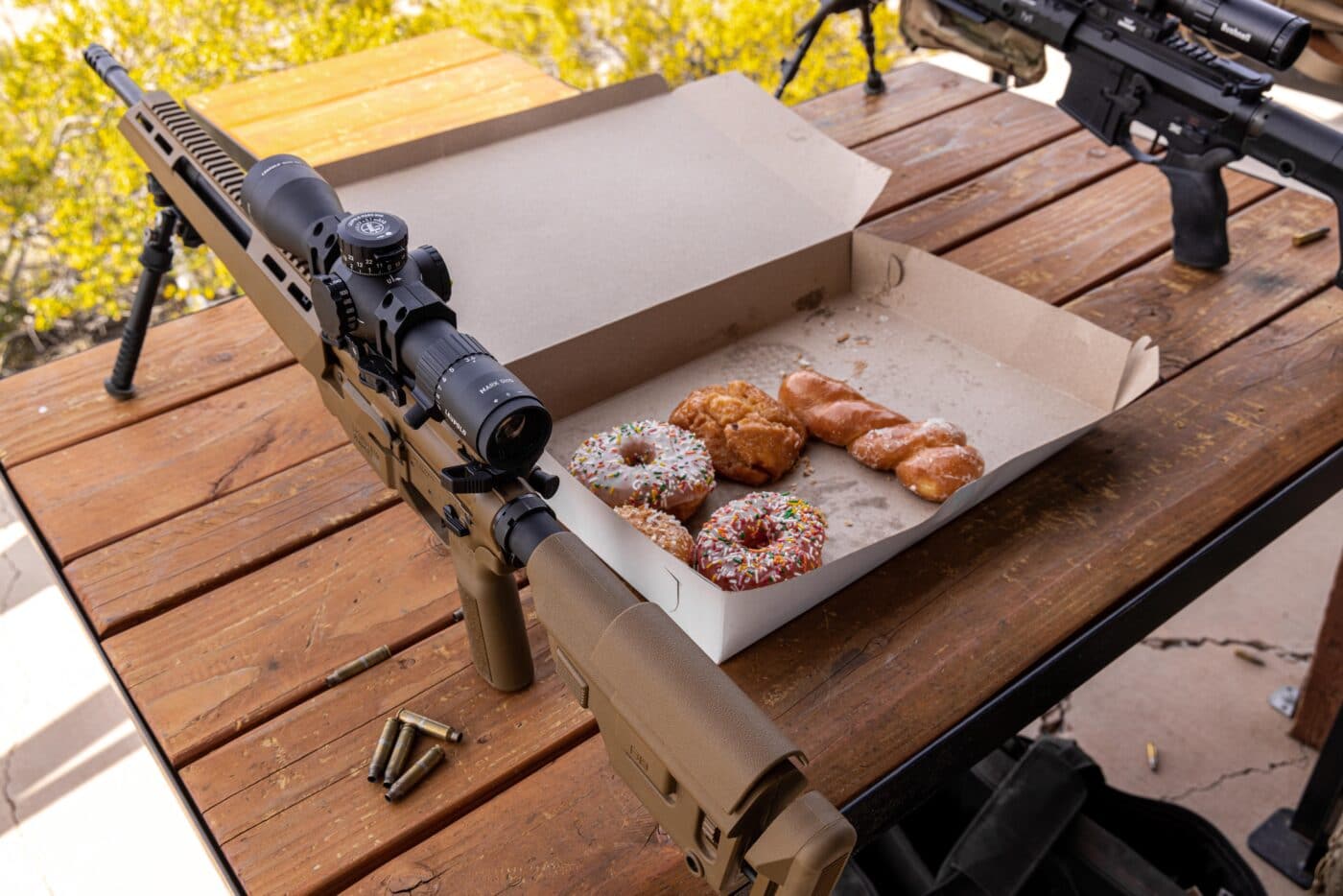 Donuts next to rifles at a shooting range