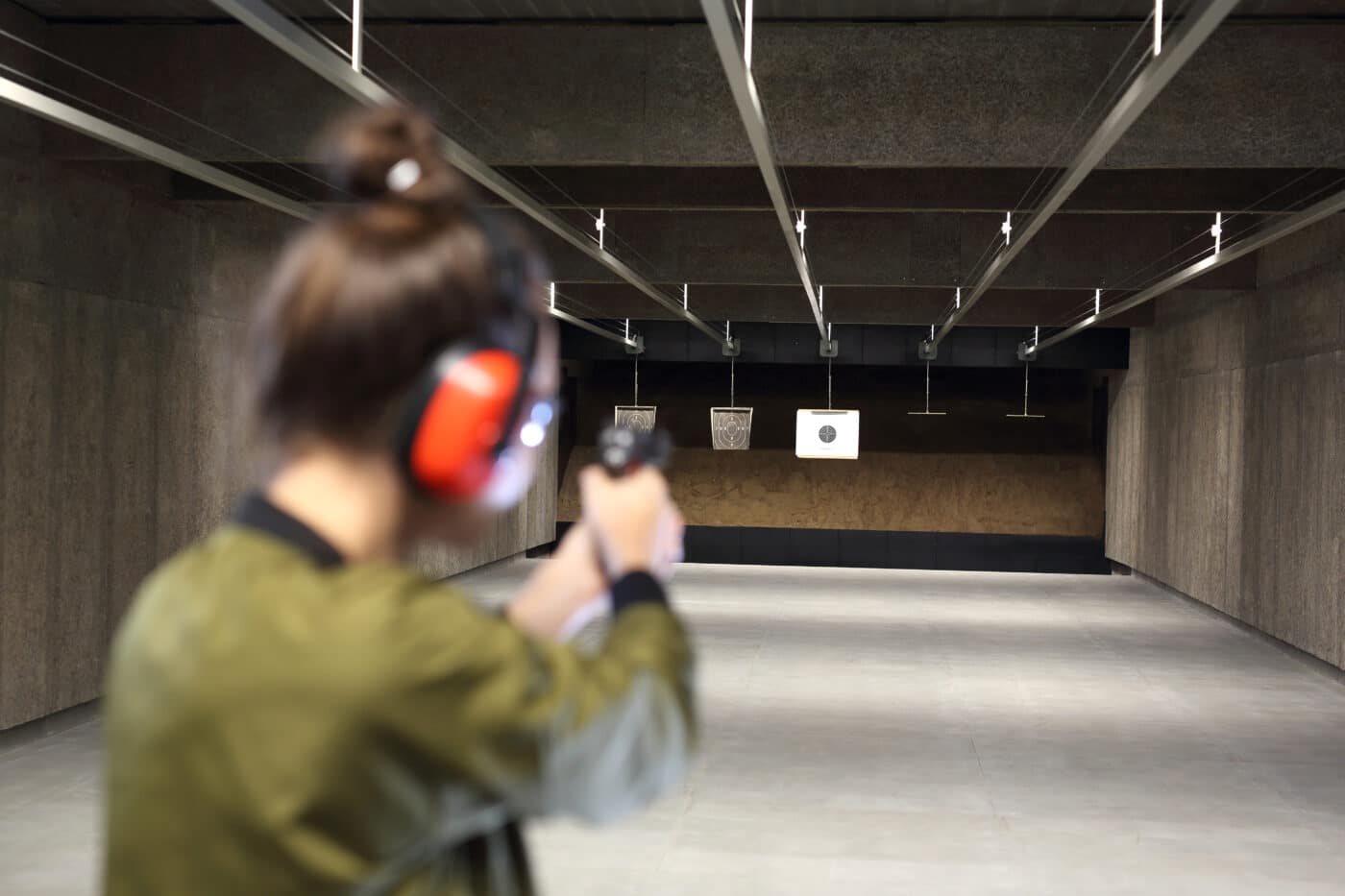 Woman shooting pistol at indoor gun range