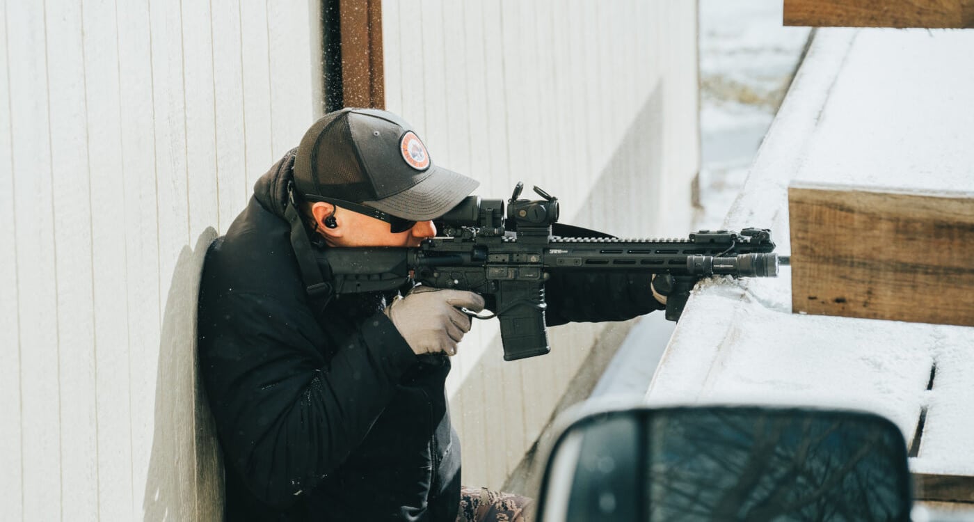 Man shooting a rifle for self defense in a rural setting