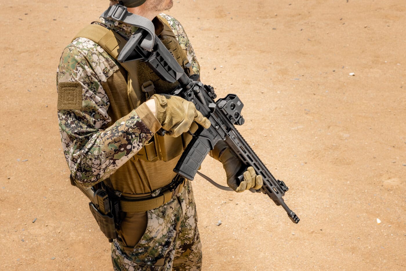 Man carrying an AR-15 in the low ready position