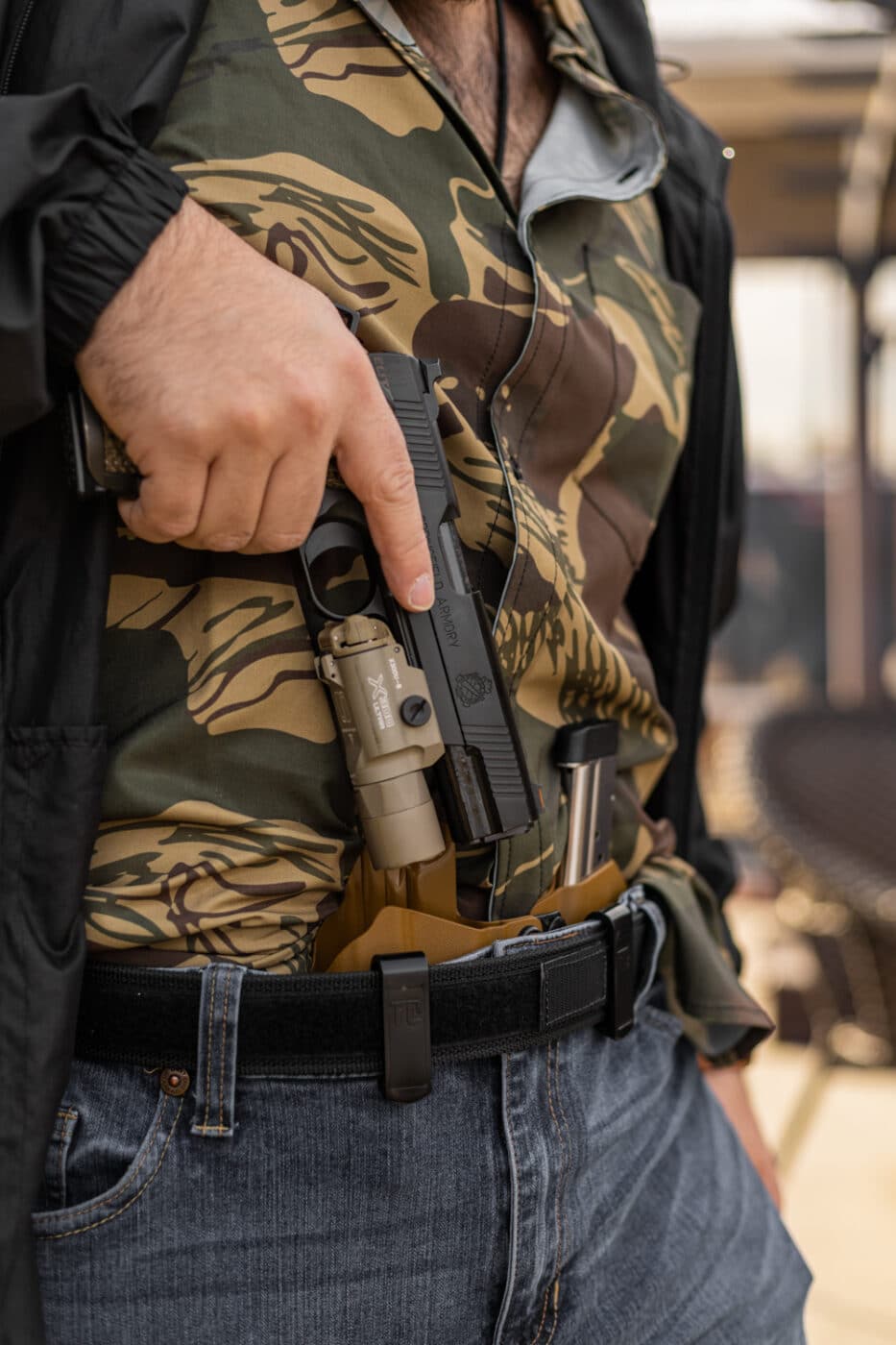 Man carrying a 1911 pistol in an appendix holster