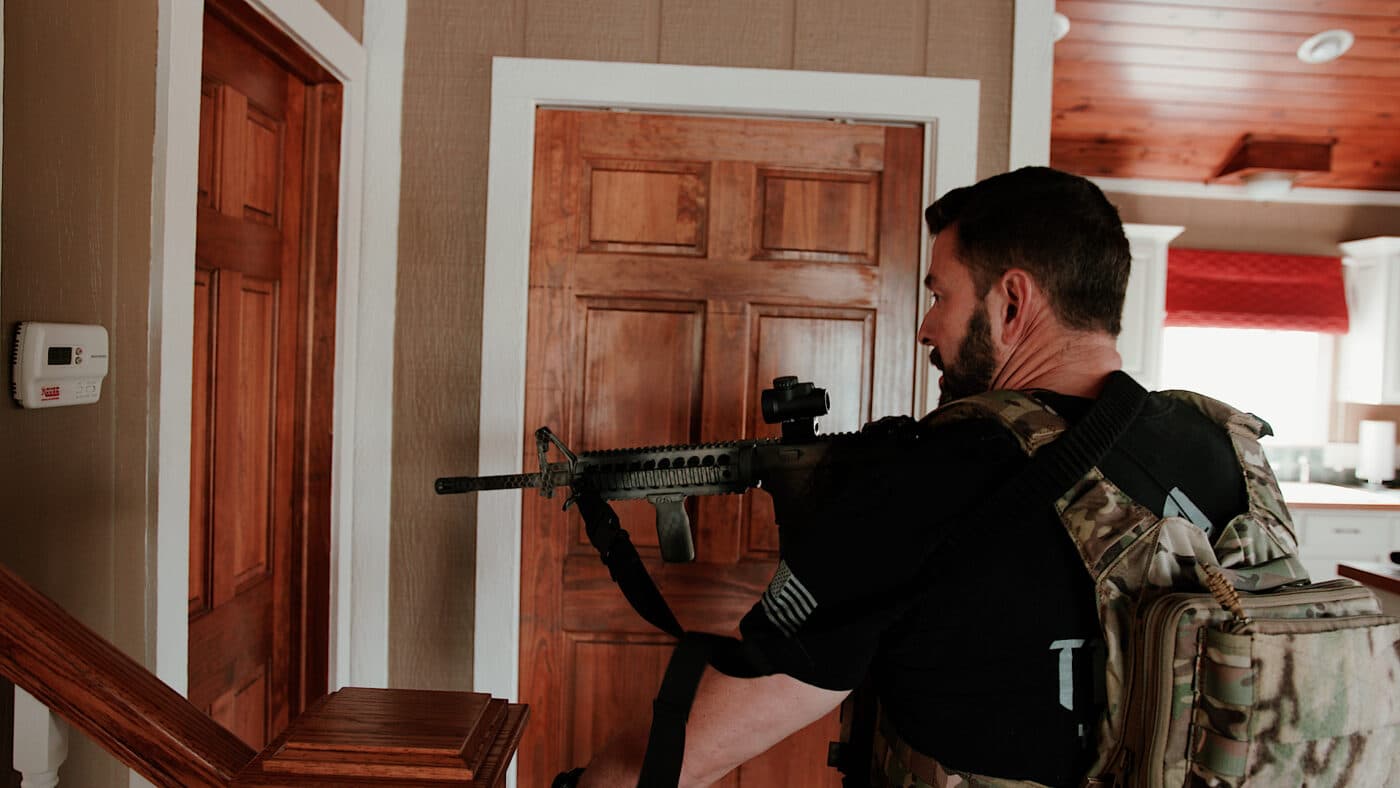 Man with AR rifle clearing a home