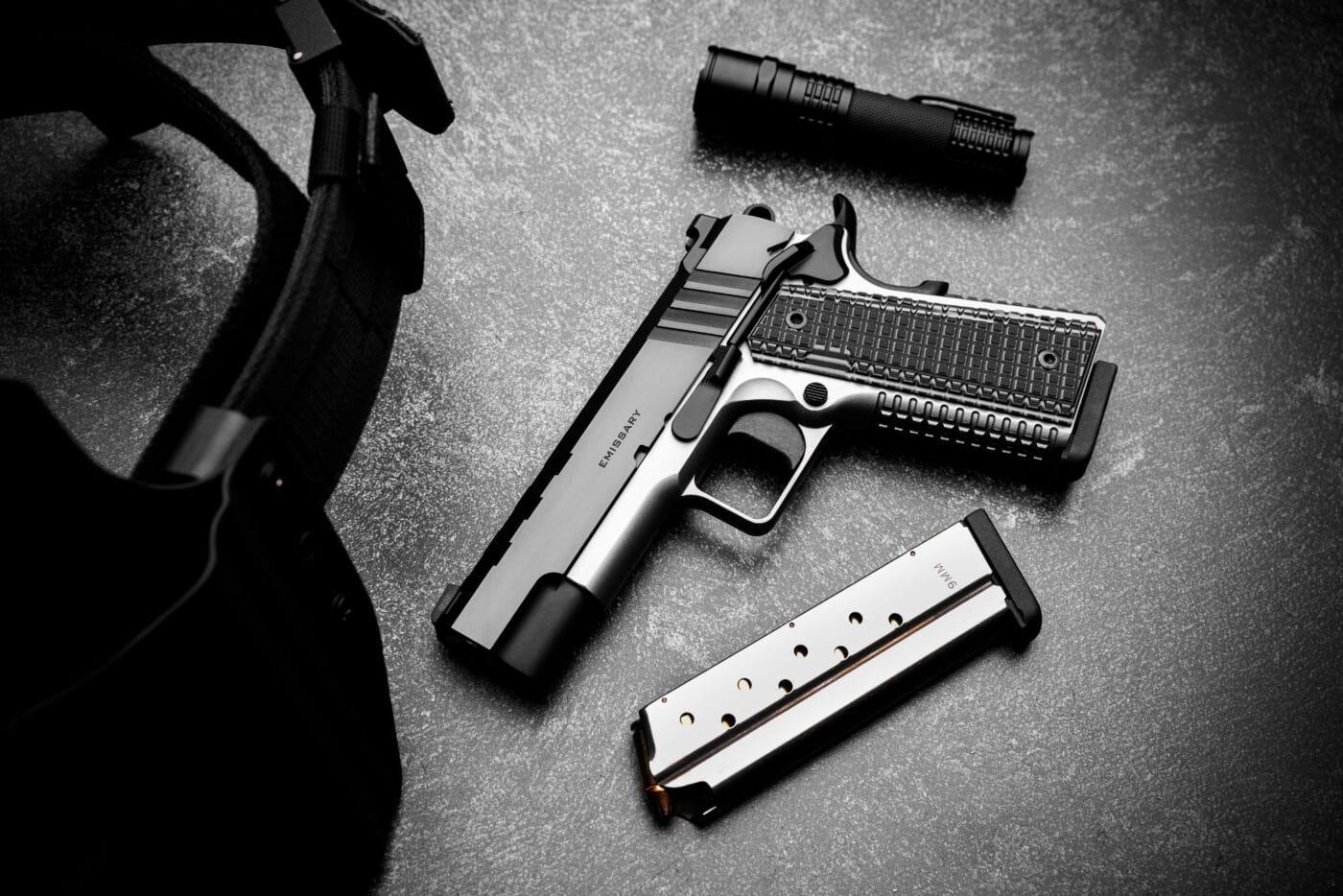 Springfield Emissary 1911 pistol next to loaded magazine and flashlight for CCW/EDC usage