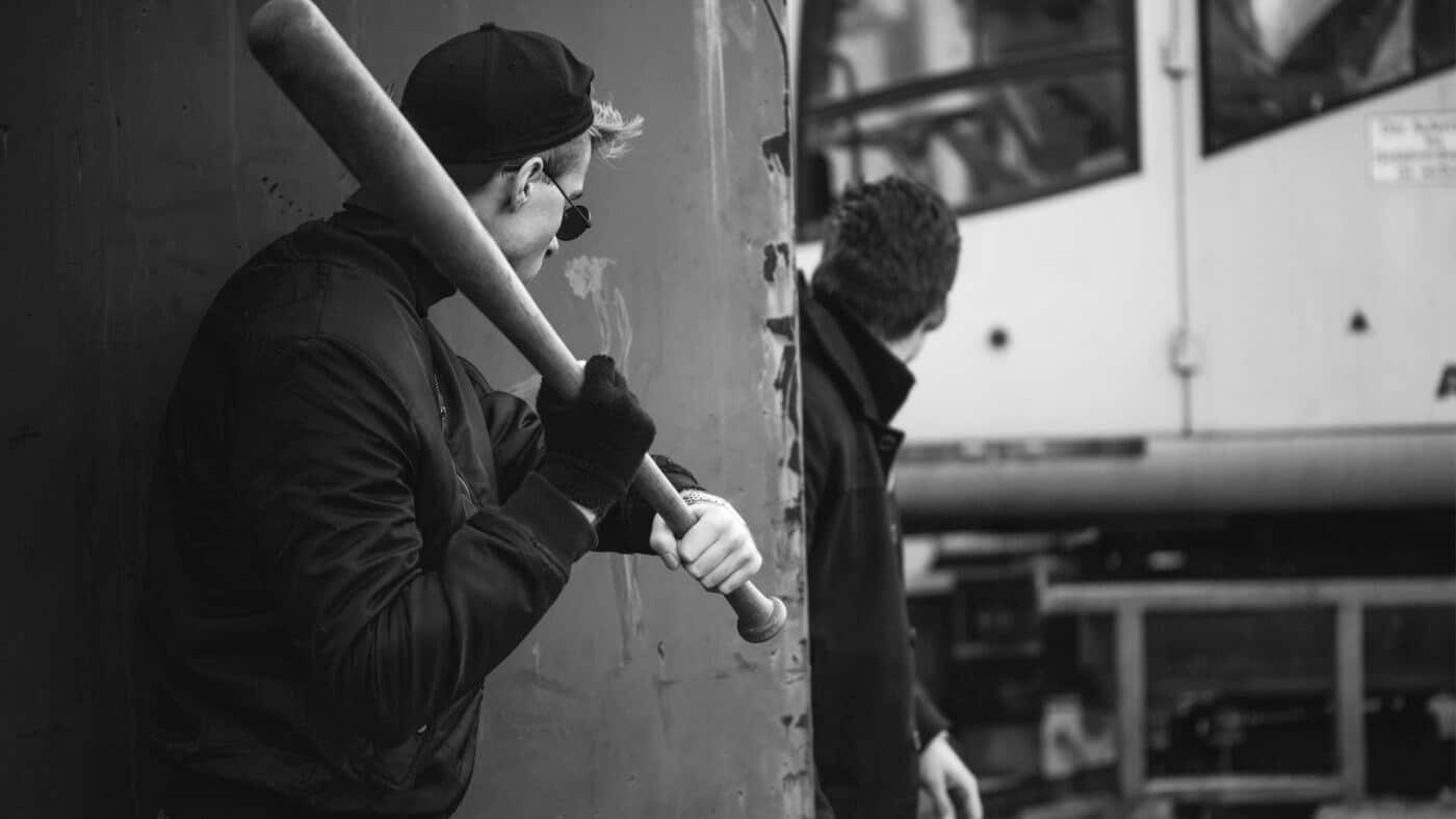 Man carrying a bat as a weapon