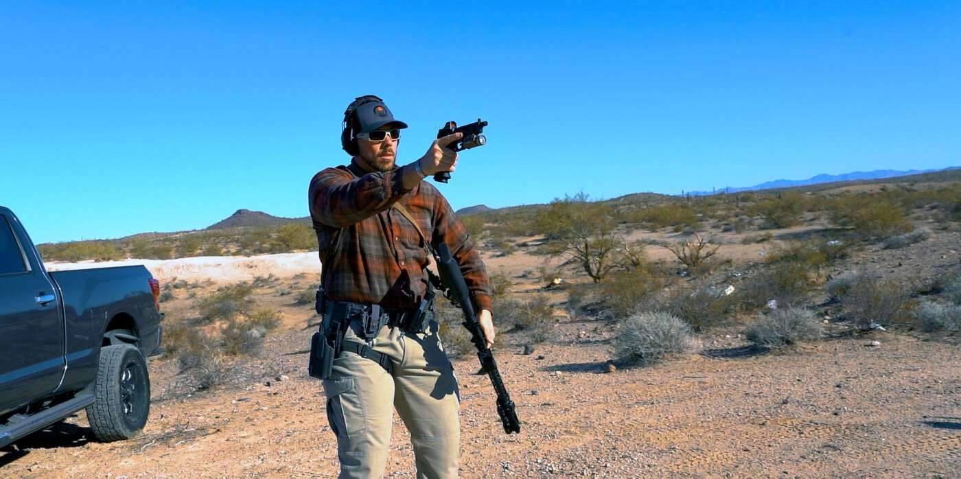Man practicing shooting drills while transitioning from rifle to handgun