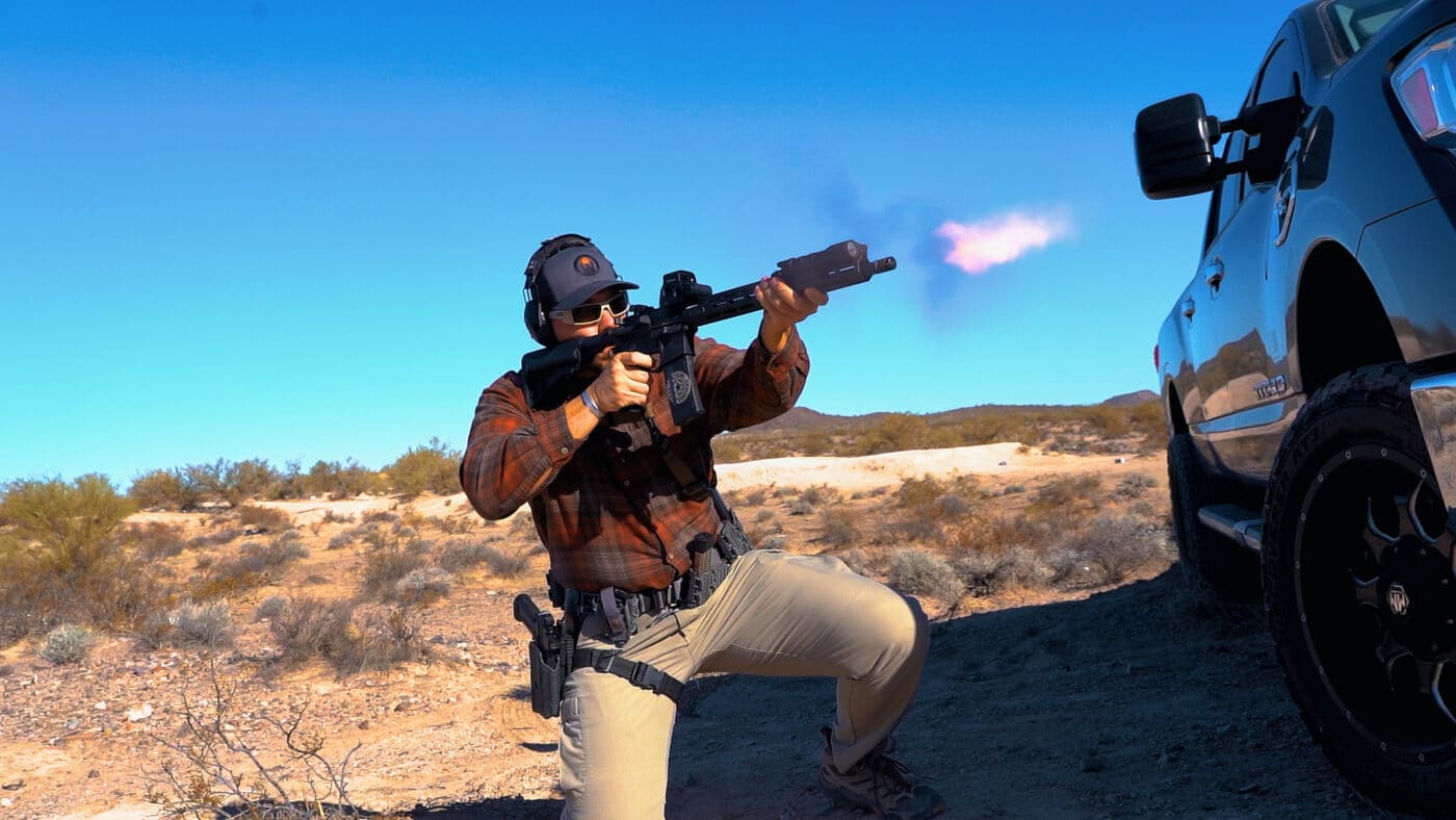 Man using a car engine block for cover during rifle training