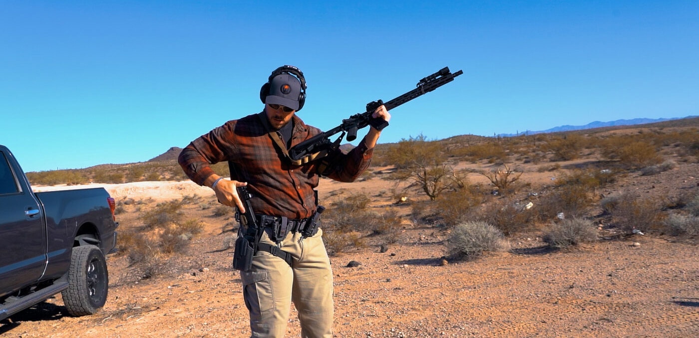 Man looking at pistol while reholstering