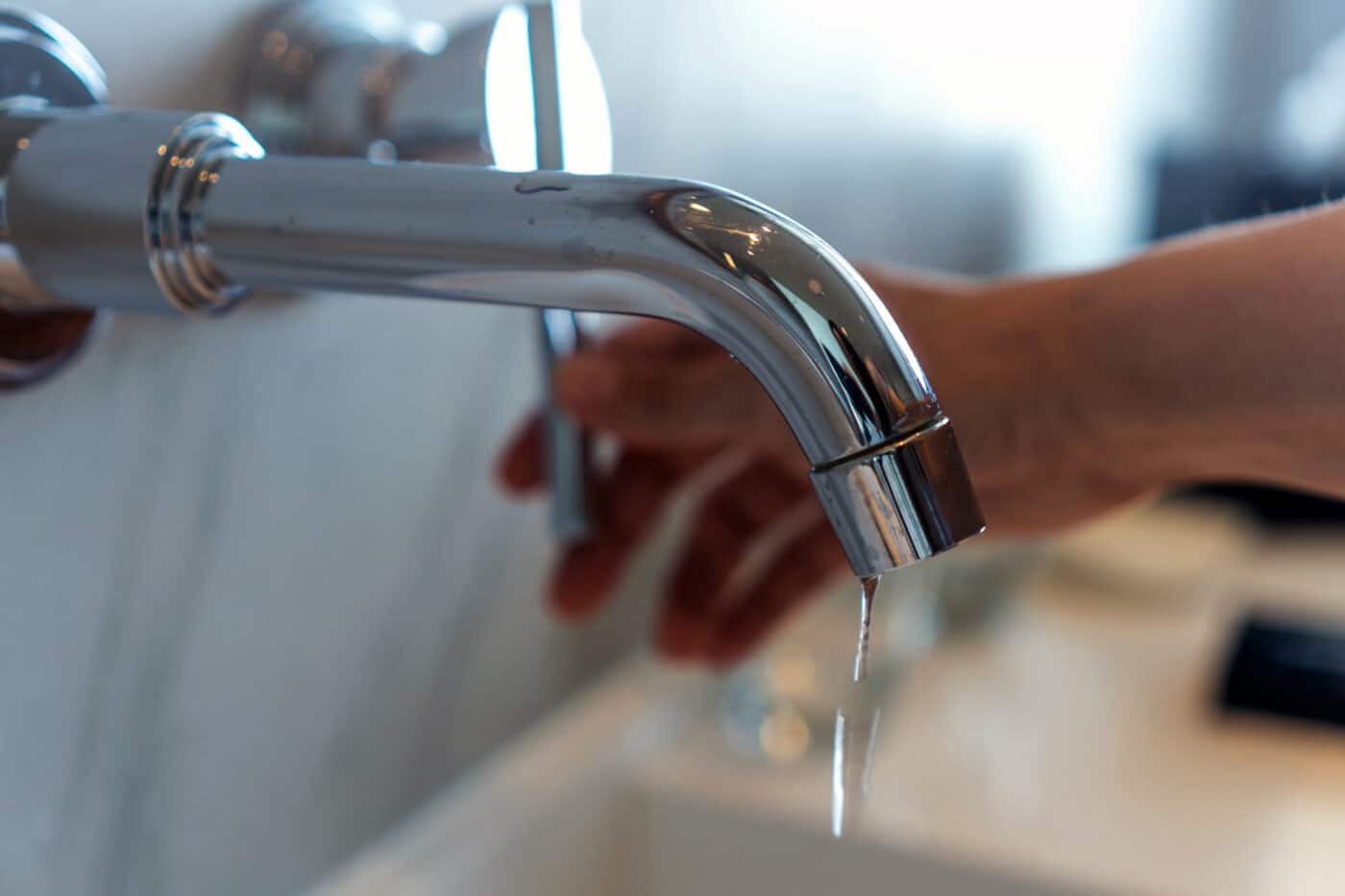 Close up of person using a faucet