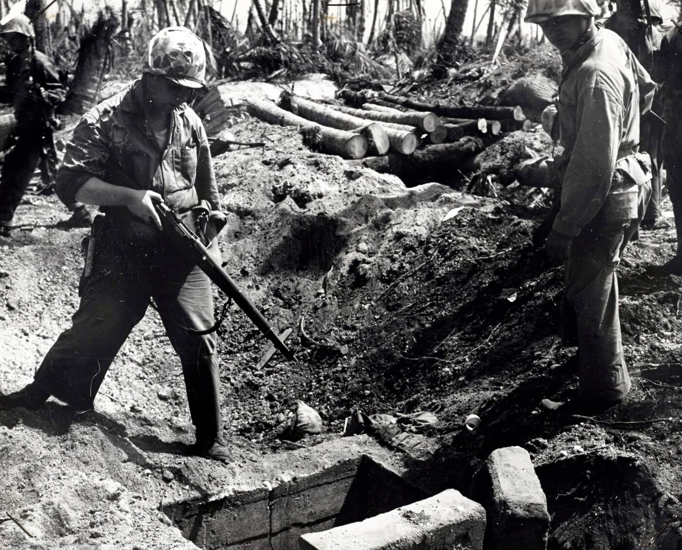 US Marine with M1 Garand inspects a beach bunker