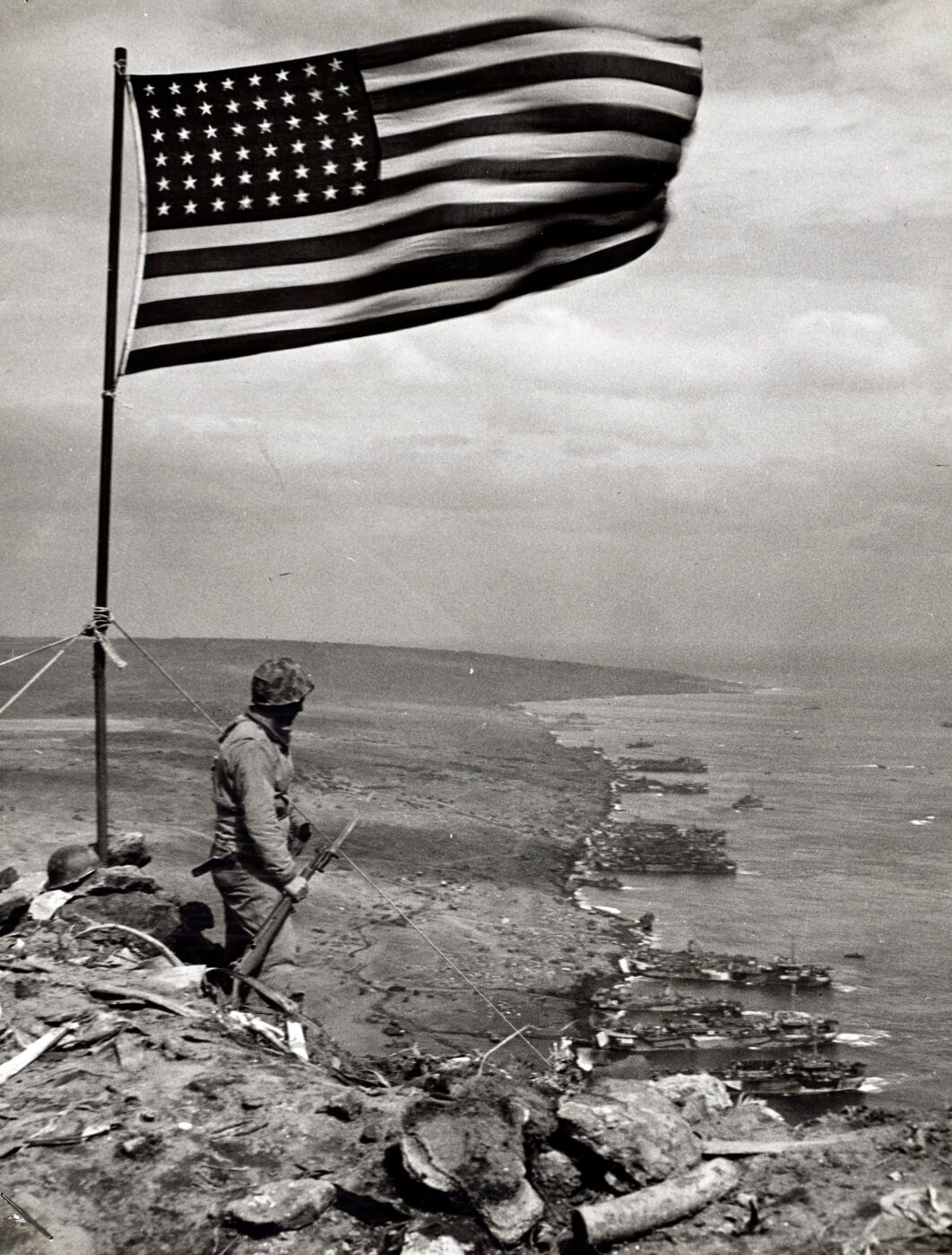 US Marine with his M1 Garand on Iwo Jima Mt Surabachi flag