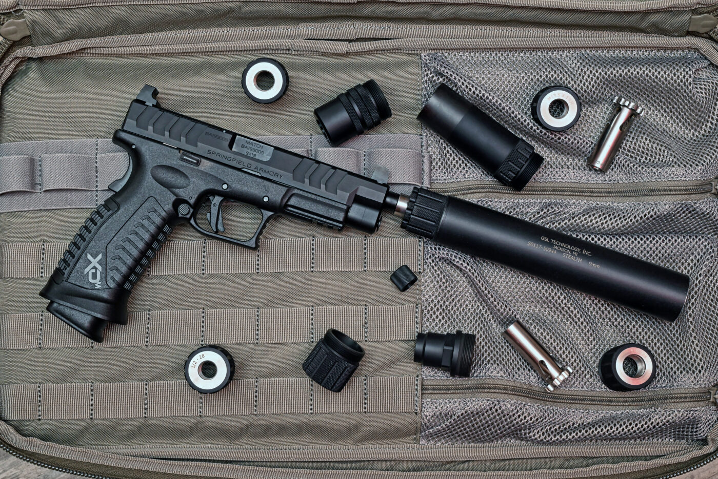 GSL noise suppressor mounted to Springfield XD-M Elite pistol with extra parts nearby