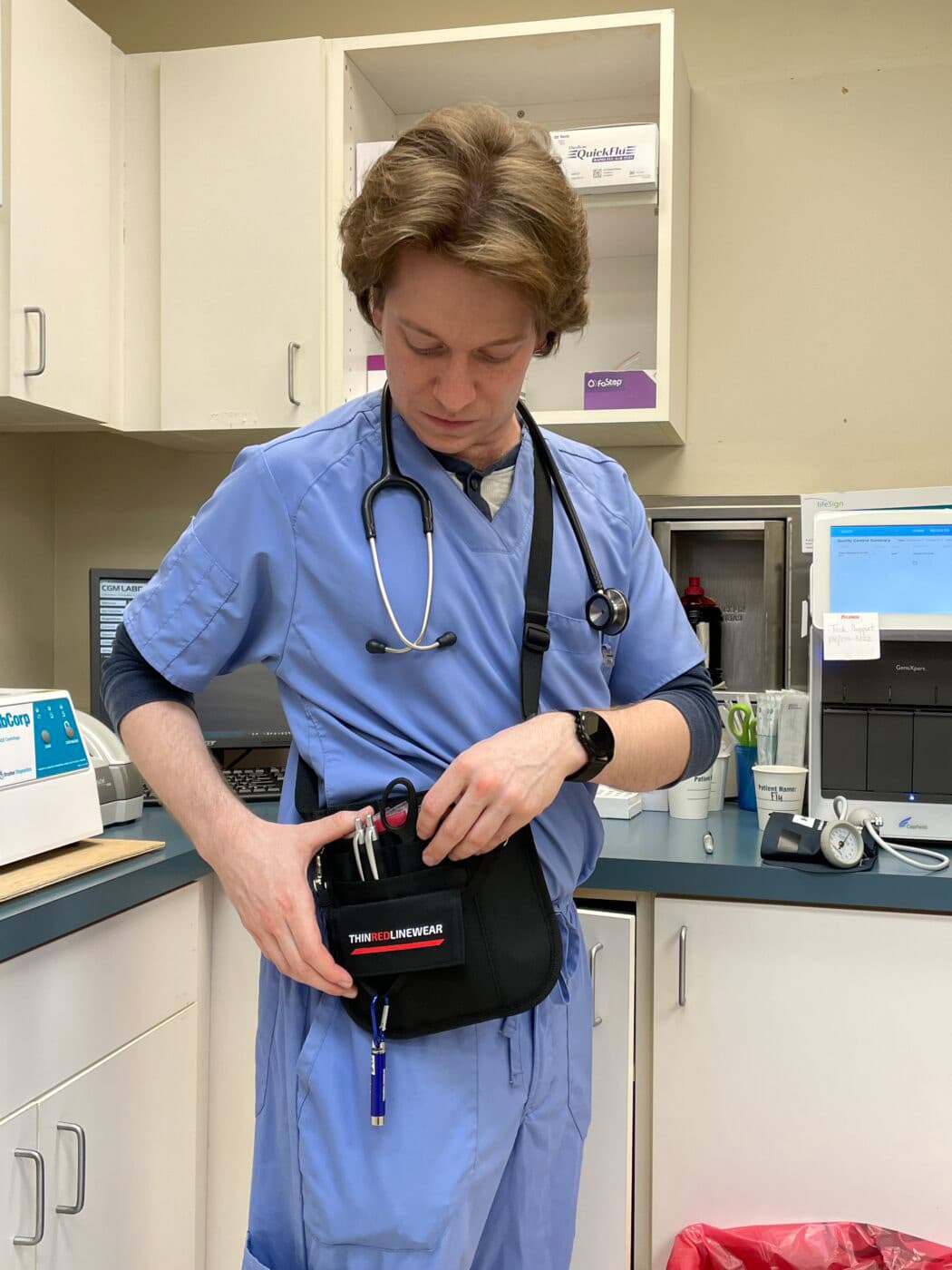 Medic professional accessing a Thin Red Line Wear bag at waist