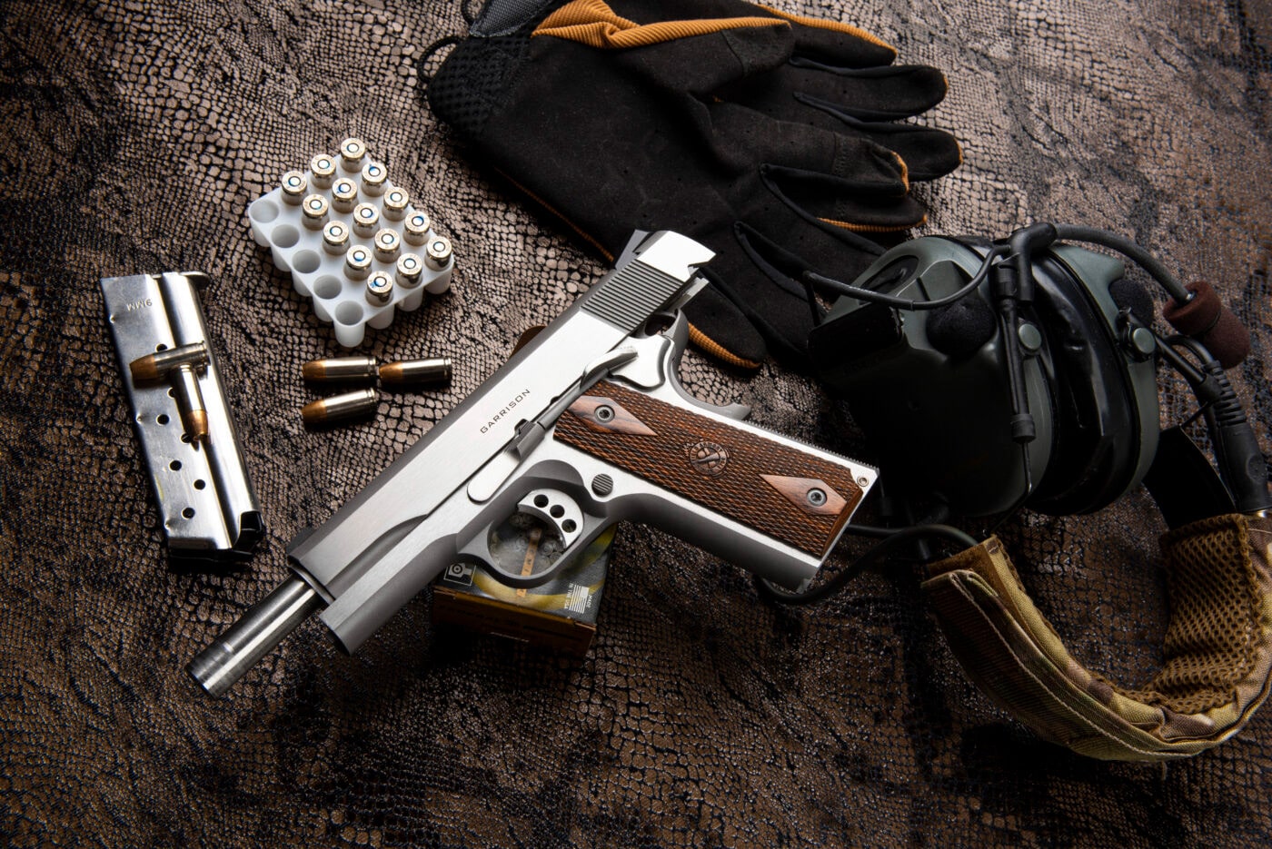 Springfield Armory 1911 Garrison pistol next to magazine and ammo