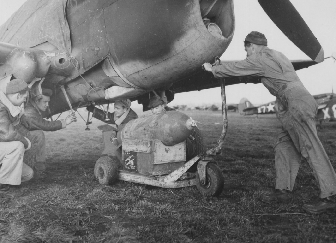 loading a bomb on a p-40 warhawk in italy during world war ii