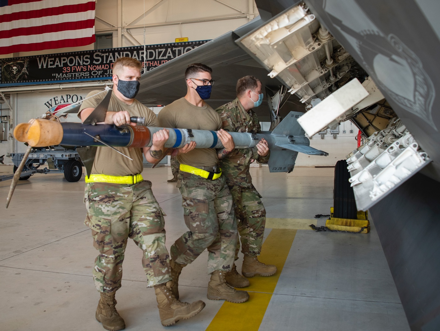 ground crew loads aim sidewinder into f-22