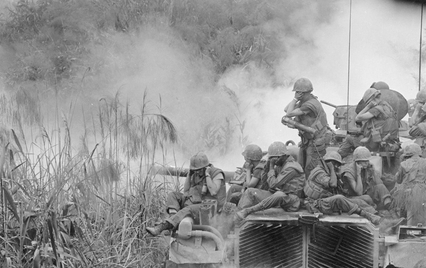 m48 patton tank engages a target in the vietnam war while marines ride on it