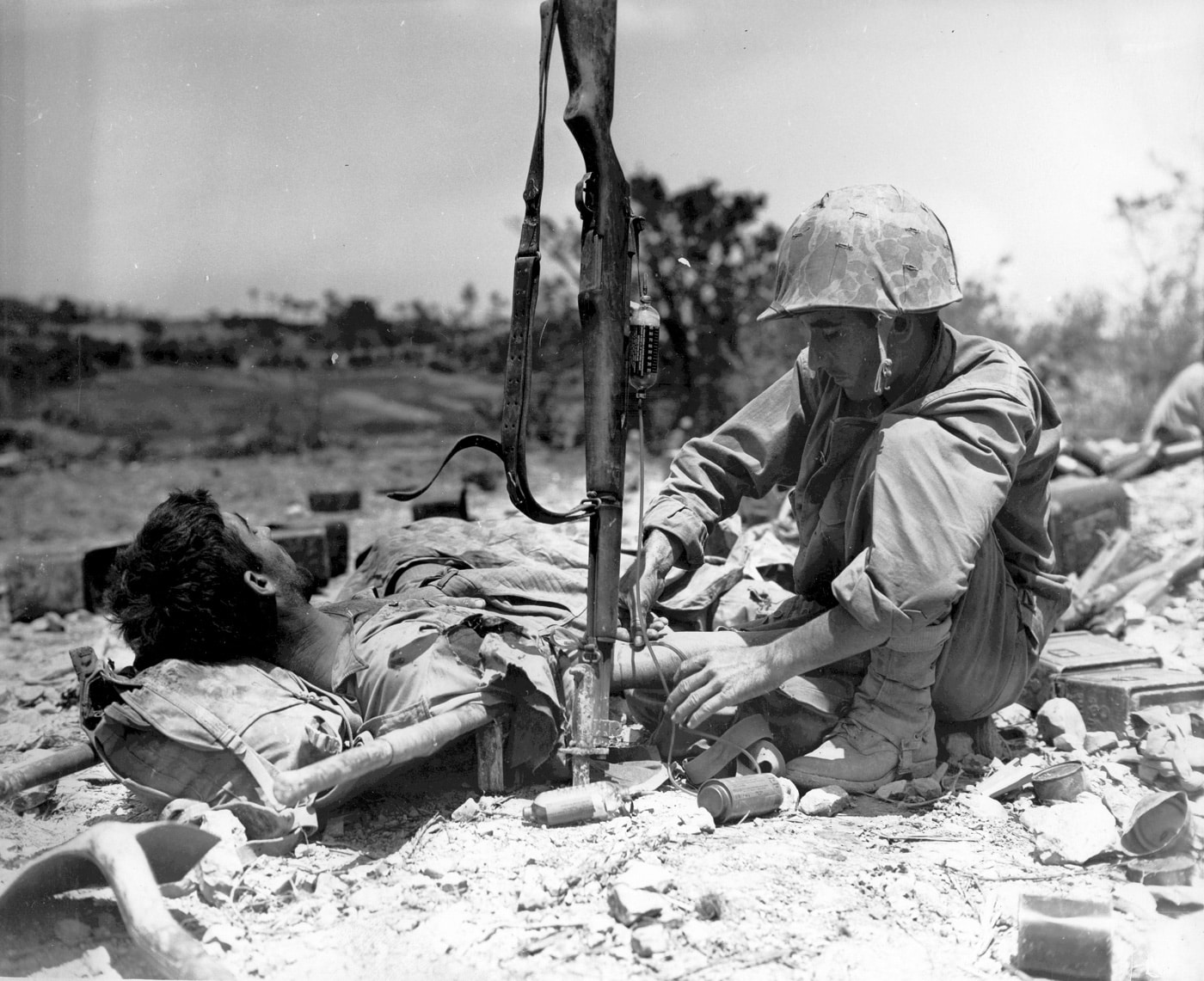 us navy corpsman gives plasma to a wounded marine on onkinawa