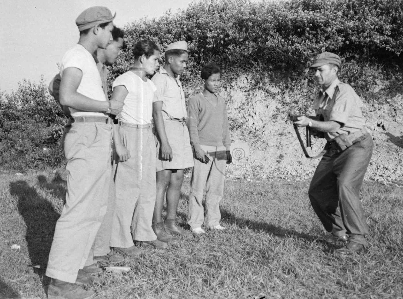 oss officer trains burmese volunteers how to use a crouching position