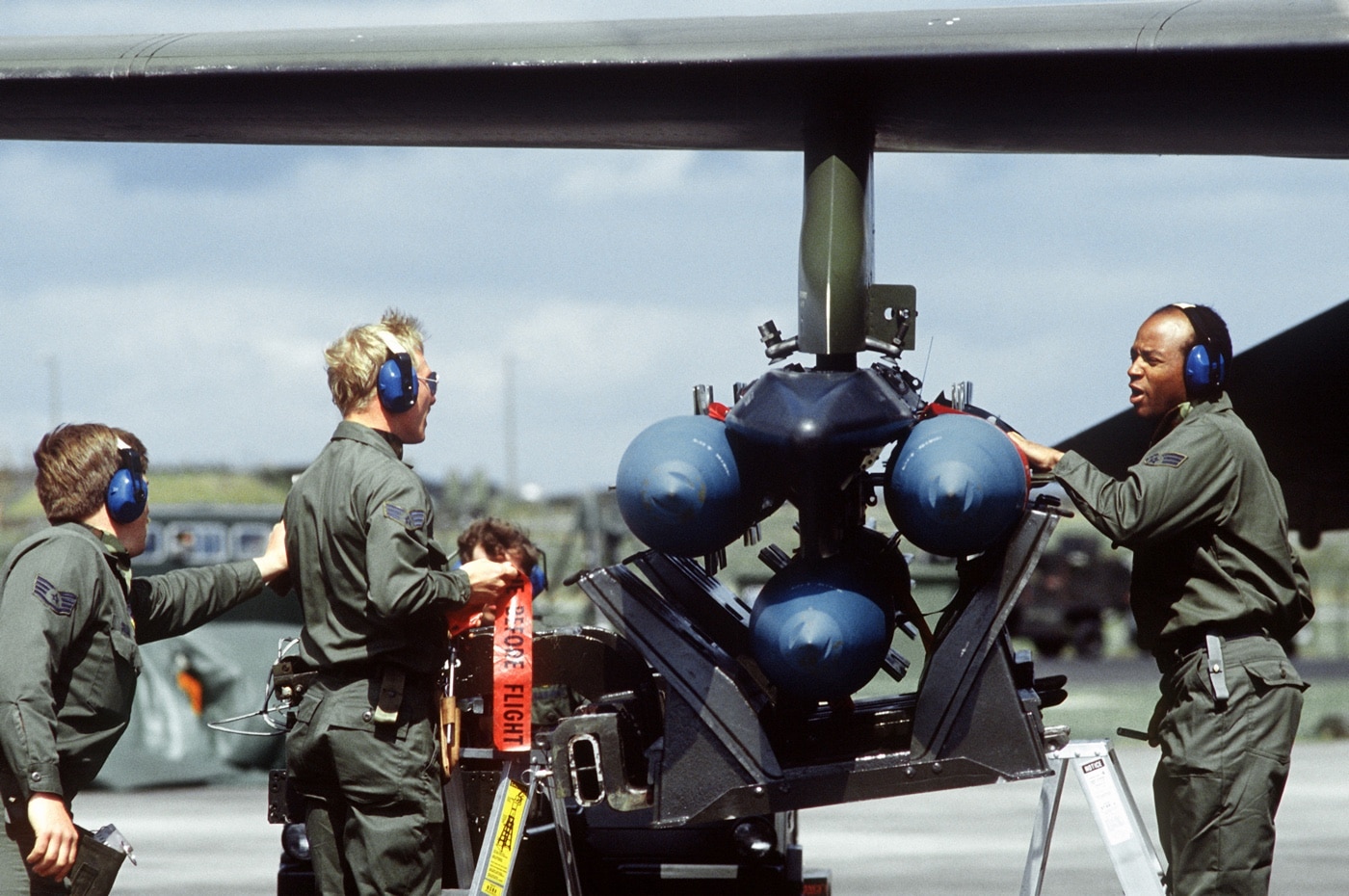 ground crew loads bombs on f-111