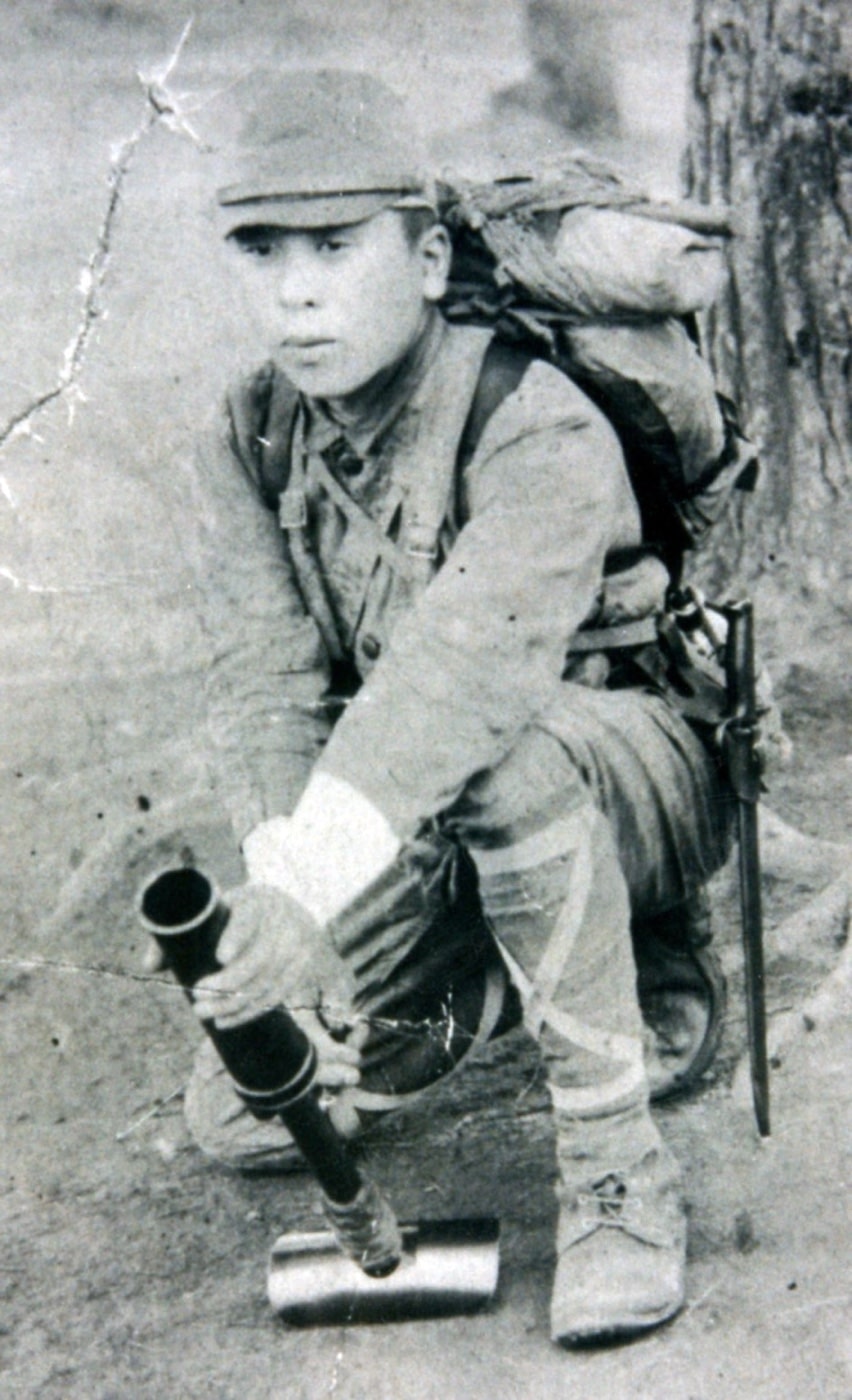 japanese soldier demonstrating use of knee mortar in world war ii