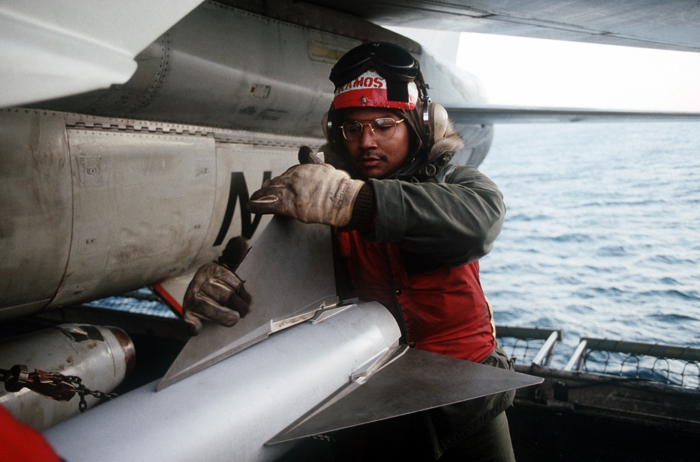 ordnance crew loads aim-7 sea sparrow on a-7 corsair on uss constellation