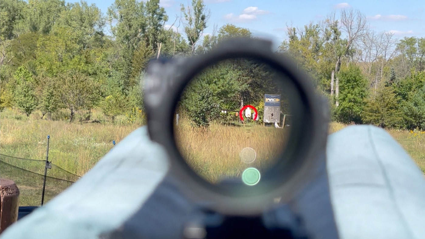 aiming the 9mm pistol caliber carbine to test accuracy and effective range using a prism scope sighted in at 50 yards