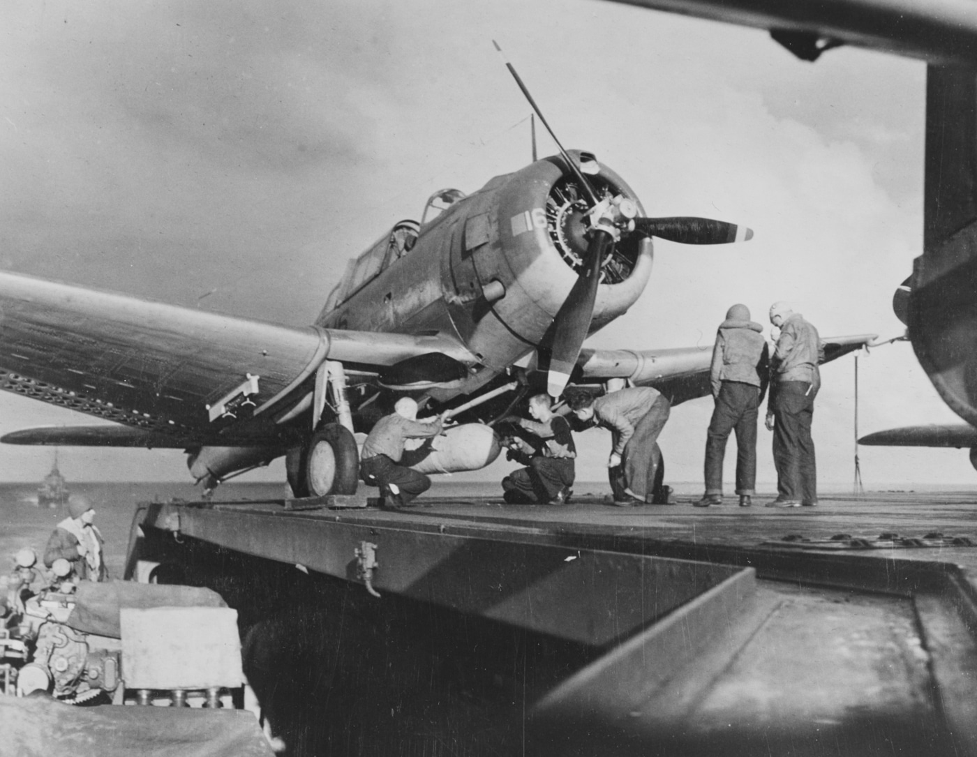 sailors load a 1000 pound bomb on a sbd dauntless