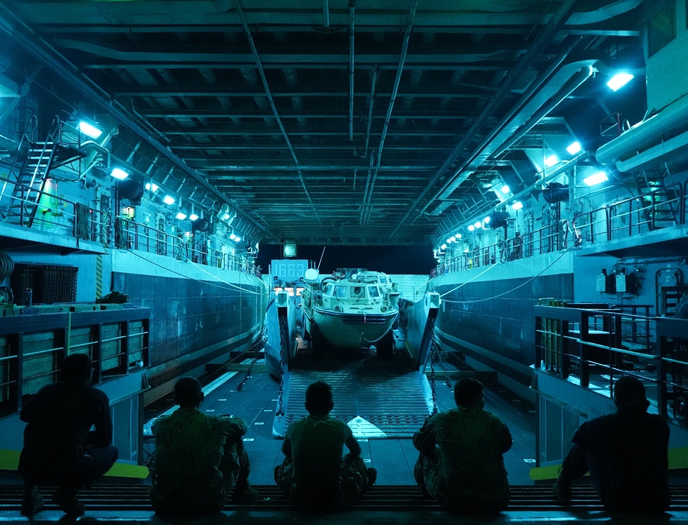 us marines watch a landing craft loaded on uss mesa verde