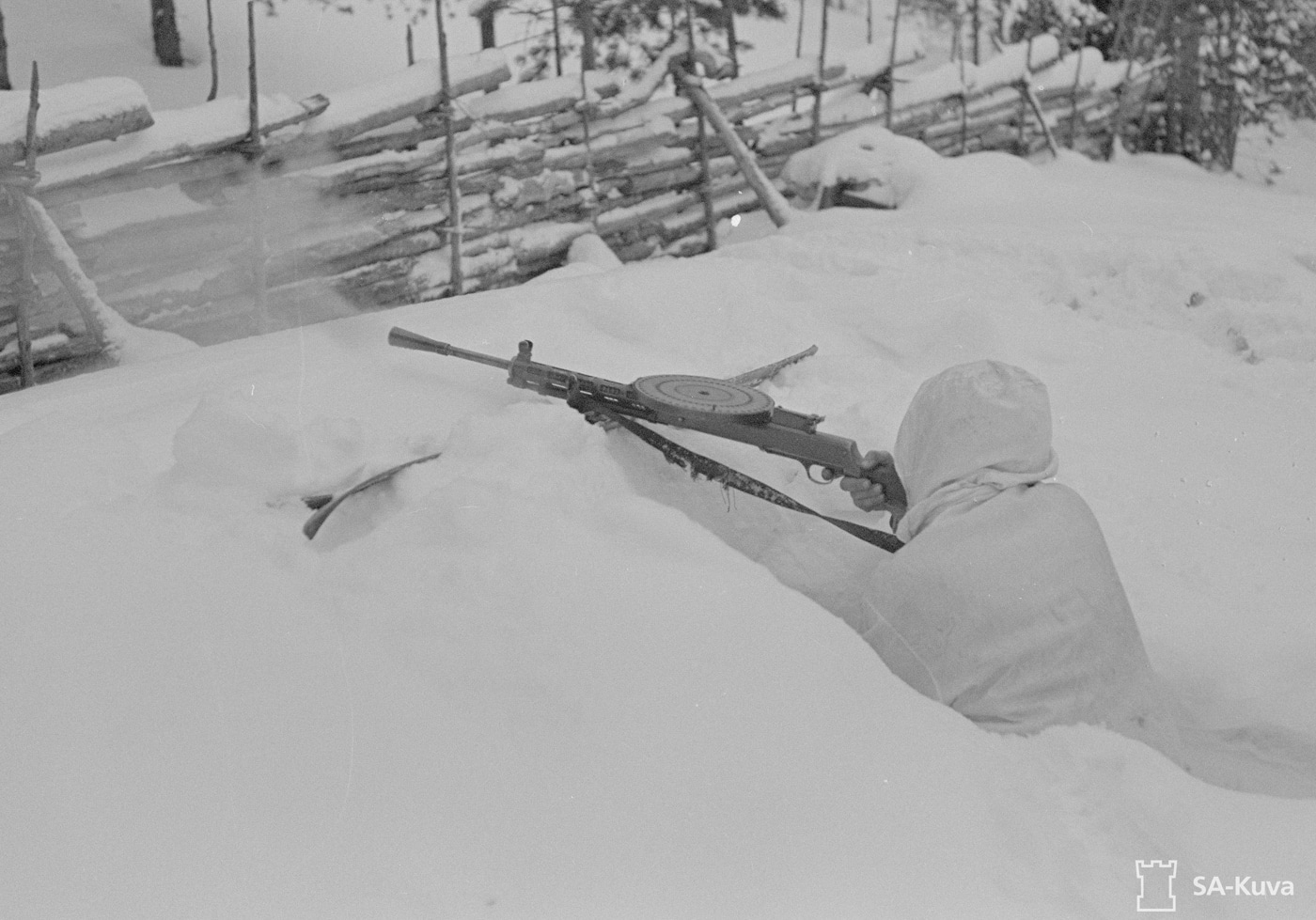 finnish soldier fires dp-27 machine gun in the snow captured from ussr troops in winter war