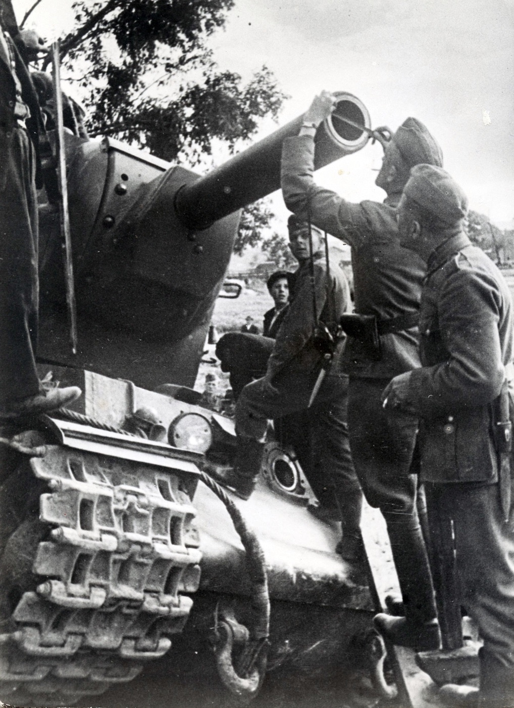 german military intelligence team inspects barrel of kv-2 heavy tank in russia