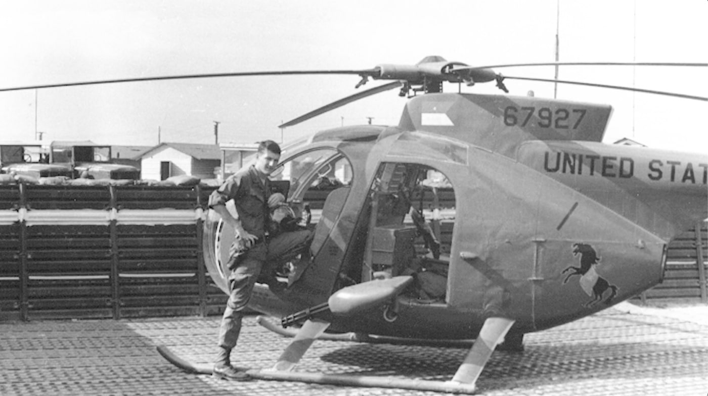 hugh mills with oh-6a helicopter mini gun visible