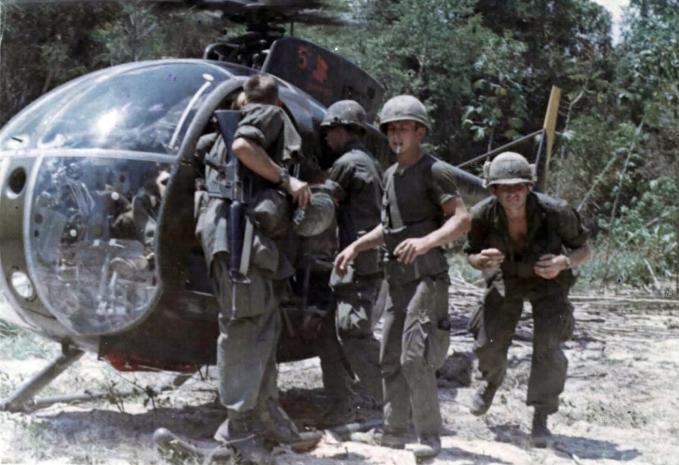 us soldiers 25th infantry division load captured intelligence documents into oh-6a helicopter at tay ninh pavn training center 1970