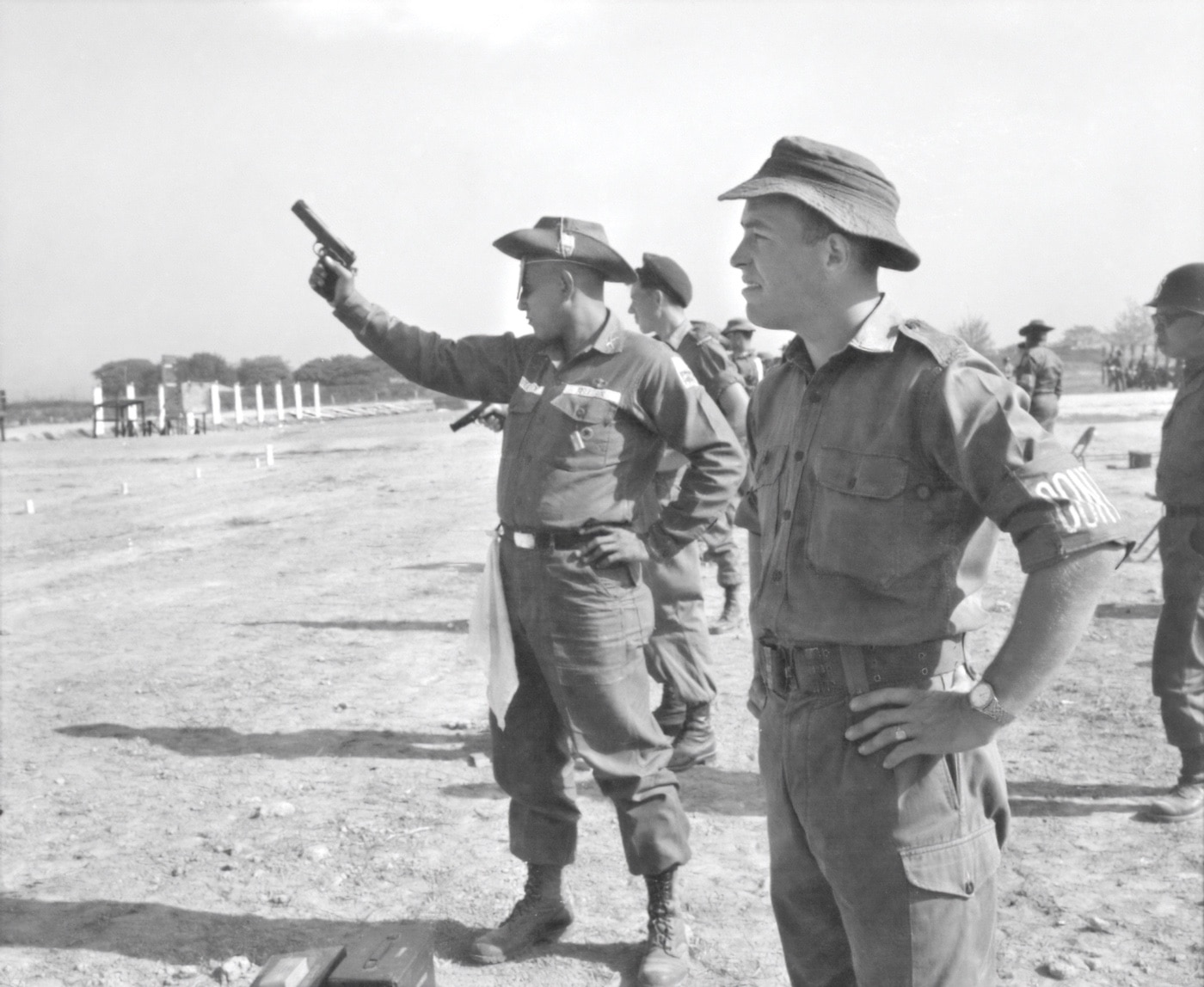 The photo shows Filipino and Australian soldiers participating in a shooting competition outside of Saigon. The competition was for all of the Allied nations deployed to Vietnam. He is shooting one handed with a M1911 pistol.