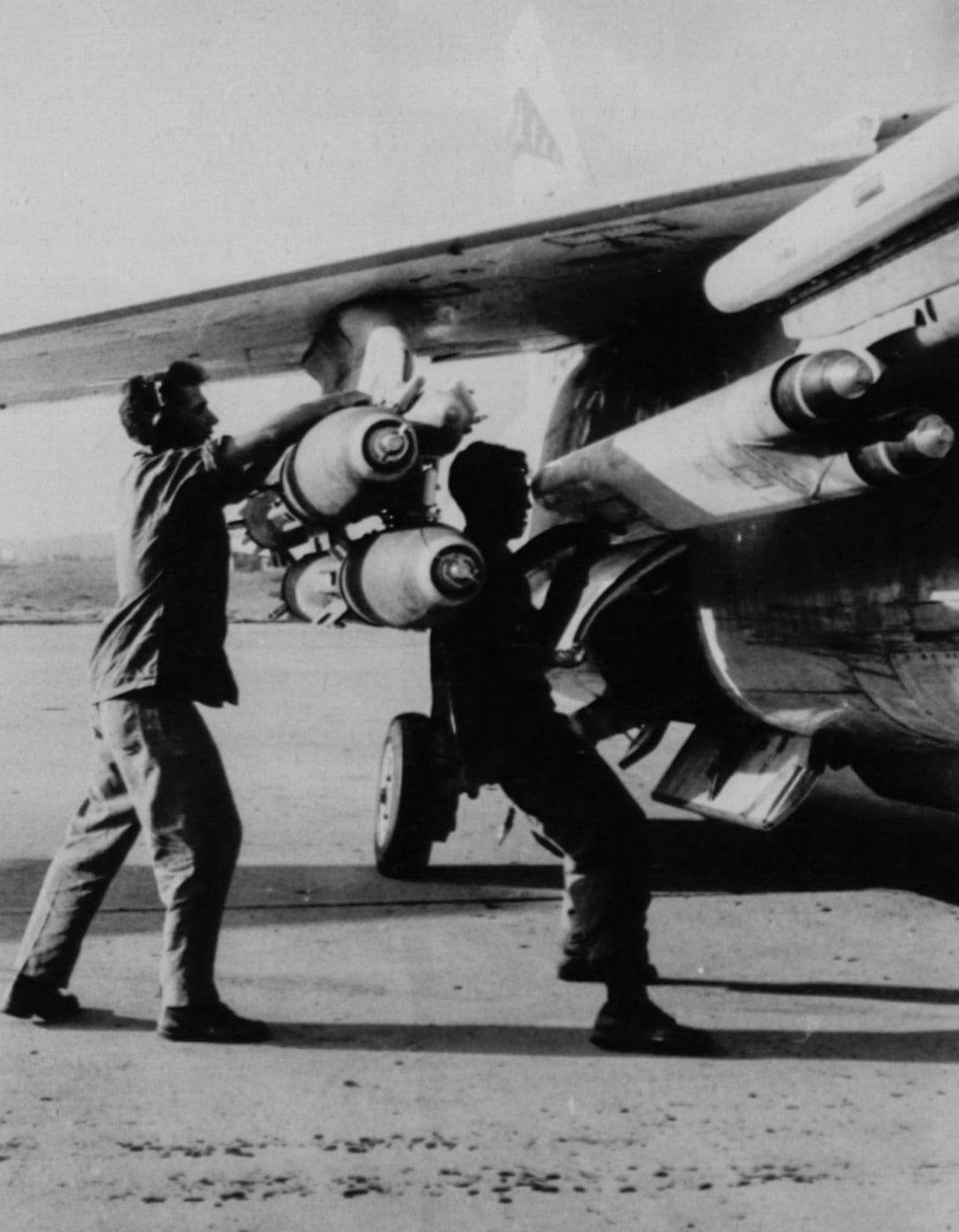 In this photo, Marines load bombs and missiles onto a Crusader during the Vietnam War. Although the plane was the first supersonic jet fighter used by the Navy and Marine Corps, it was frequently used for ground attack in combat during the Vietnam War. These jet aircraft were good in a dogfight against Vietnamese MIGs in Southeast Asia.