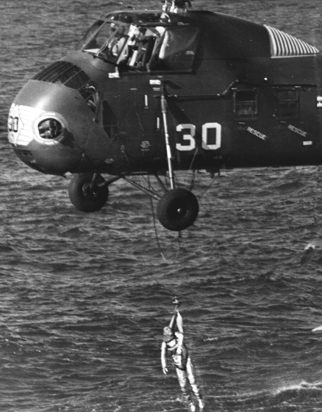 NASA astronaut Gus Grissom is rescued from the ocean by U.S. Marines in a HUS-1 Seahorse helicopter. The irony of the situation was the rescue helicopter is believed to have caused the capsule hatch to blow in the first place. NASA instead blamed Grissom and redesigned the hatch which had a direct impact on the Apollo 1 disaster in which Grissom and two other astronauts died in a fire on the launchpad.