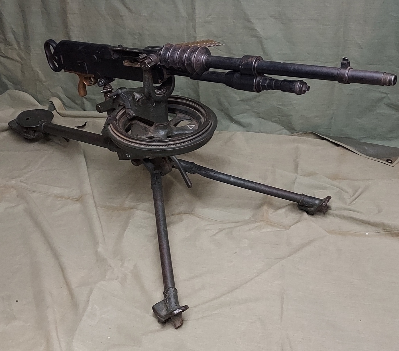 This is a photo of the author's MLE 1914 Hotchkiss machine gun in a static display. It shows the barrel, receiver, trigger, feeding mechanism, sights and more. It is mounted on a tripod.