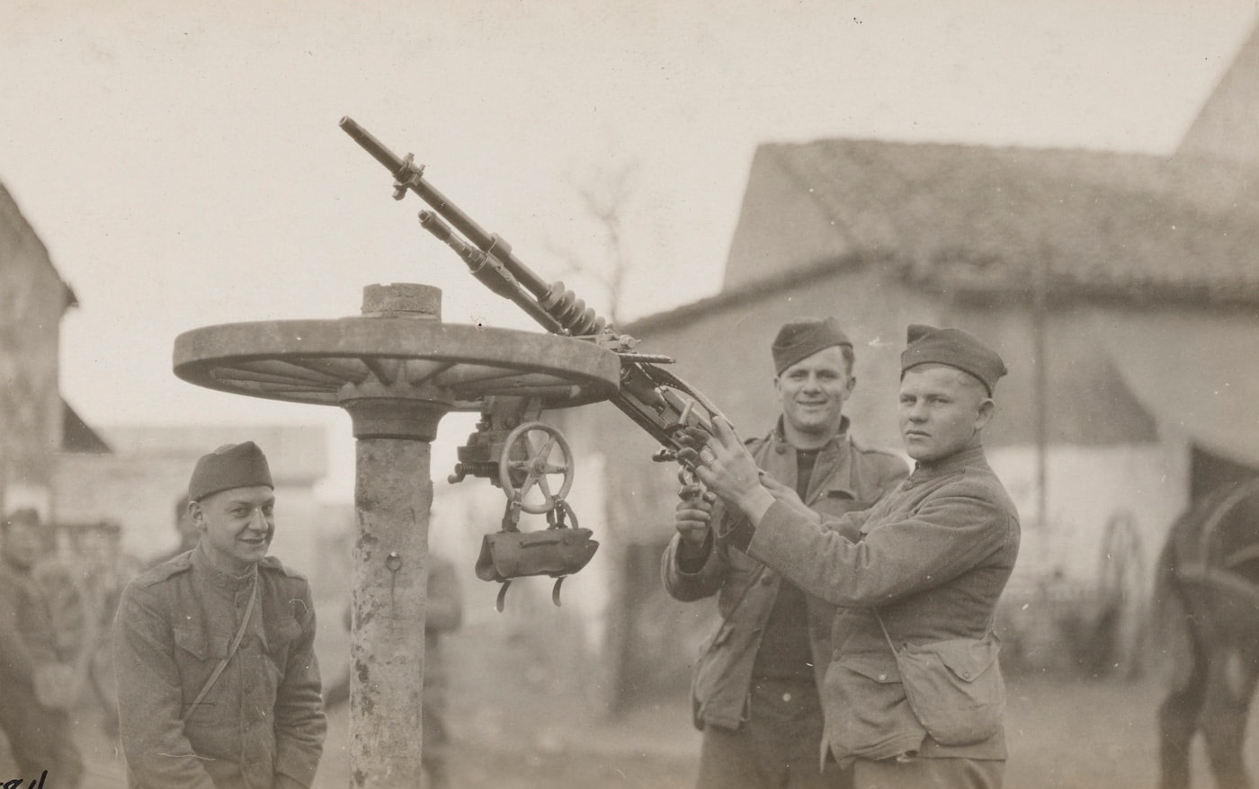 A military photographer captured the scene of U.S. soldiers that mounted a Hotchkiss machine gun to an upturned wagon wheel to improvise an anti-aircraft gun. The photo was taken near Ménil-la-Tour, France, south of Luxembourg on February 17, 1918. The uniformed soldiers were part of Battery E, Sixth Field Artillery.