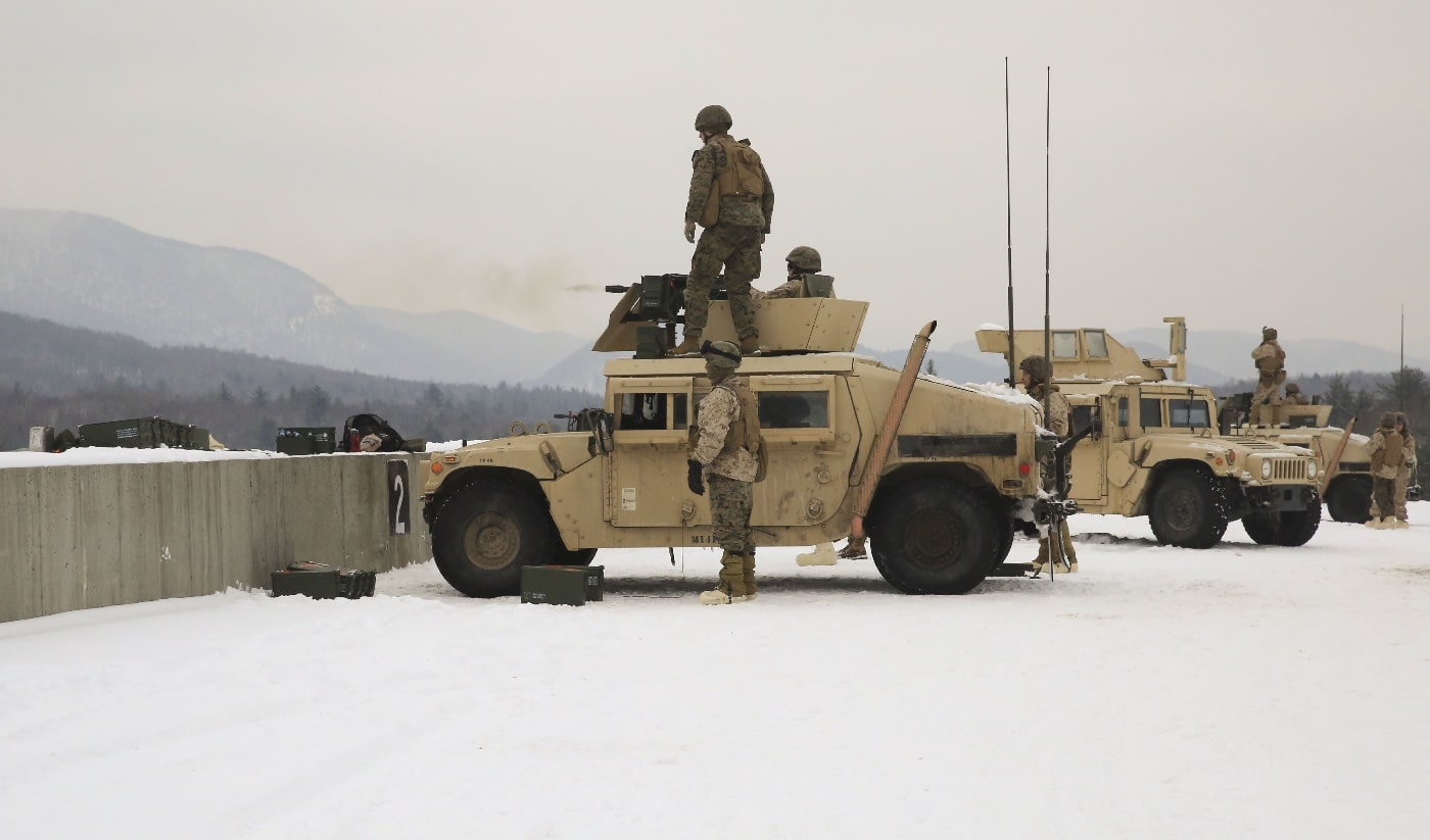 In this photo, a line of U.S. Marine Corps armored vehicles are engaged in a live fire training in the snow. 