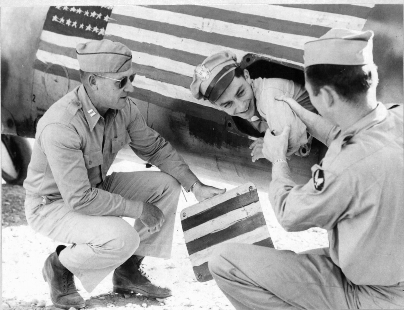 This photo shows air crews examining how Lt. Col. Gunn was able to hide in the radio compartment of the Messerschmitt. It was cramped and dangerous, but he made it.