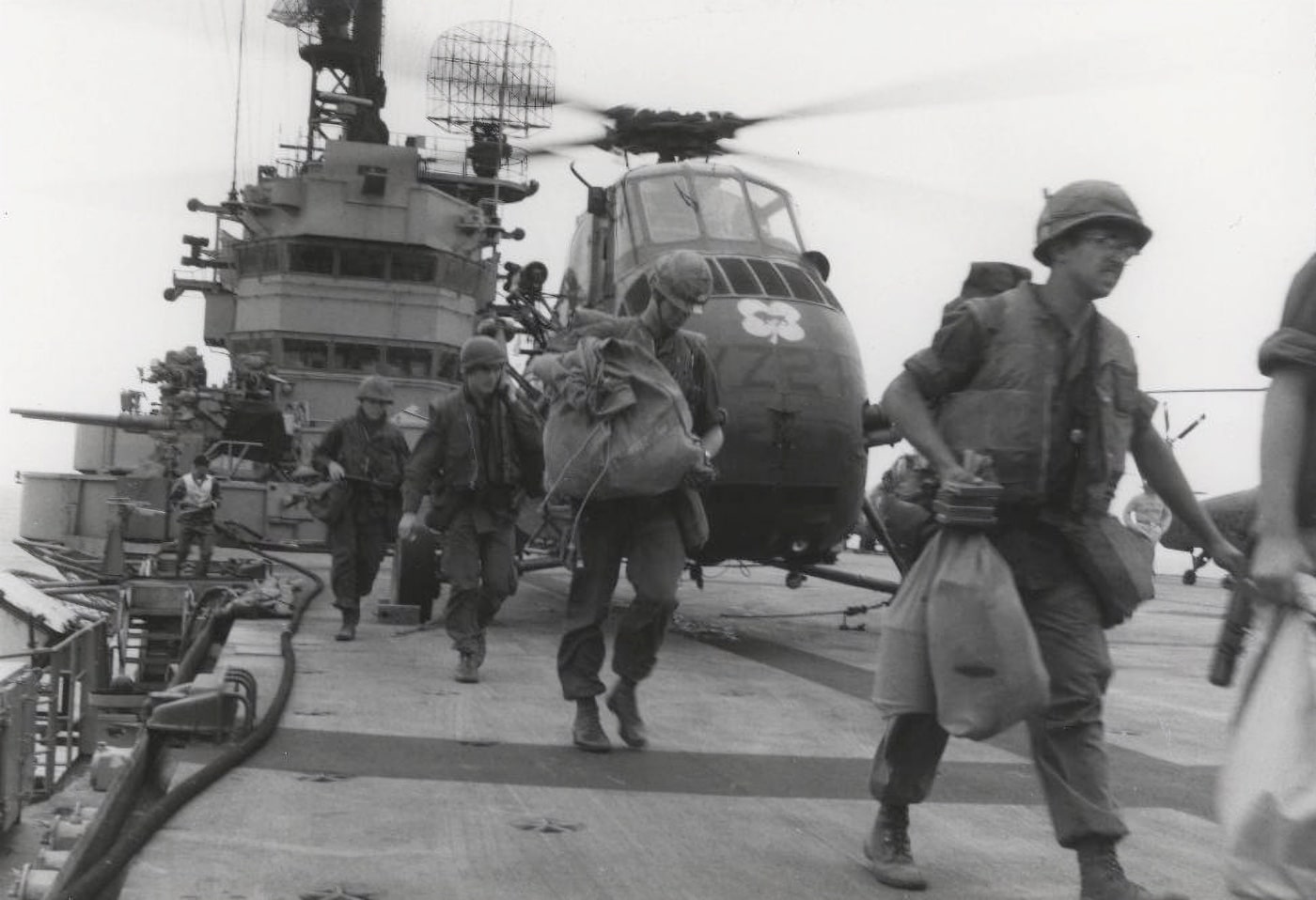 In this photo, U.S. Marines aboard the U.S. Navy ship USS Iwo Jima load their equipment and prepare for flight. The Iwo Jima is a specialized ship that is able to transport Marines and their equipment. Additionally it had a flattop like an aircraft carrier and could conduct flight operations. 