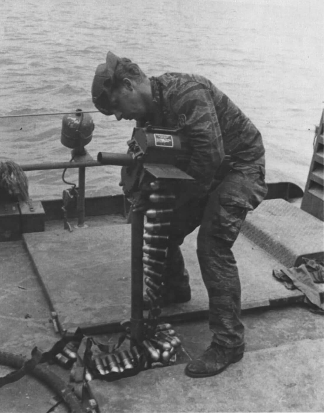 Shown is a American Navy sailor in a Tiger Strip pattern camo uniform loading a Mk18 Mod0 grenade launcher. The U.S. Navy SEALs used them on Patrol Craft Fast (PCF) boats (also known as Swift Boats) for additional firepower when patrolling the rivers and costal areas during the Vietnam War. 